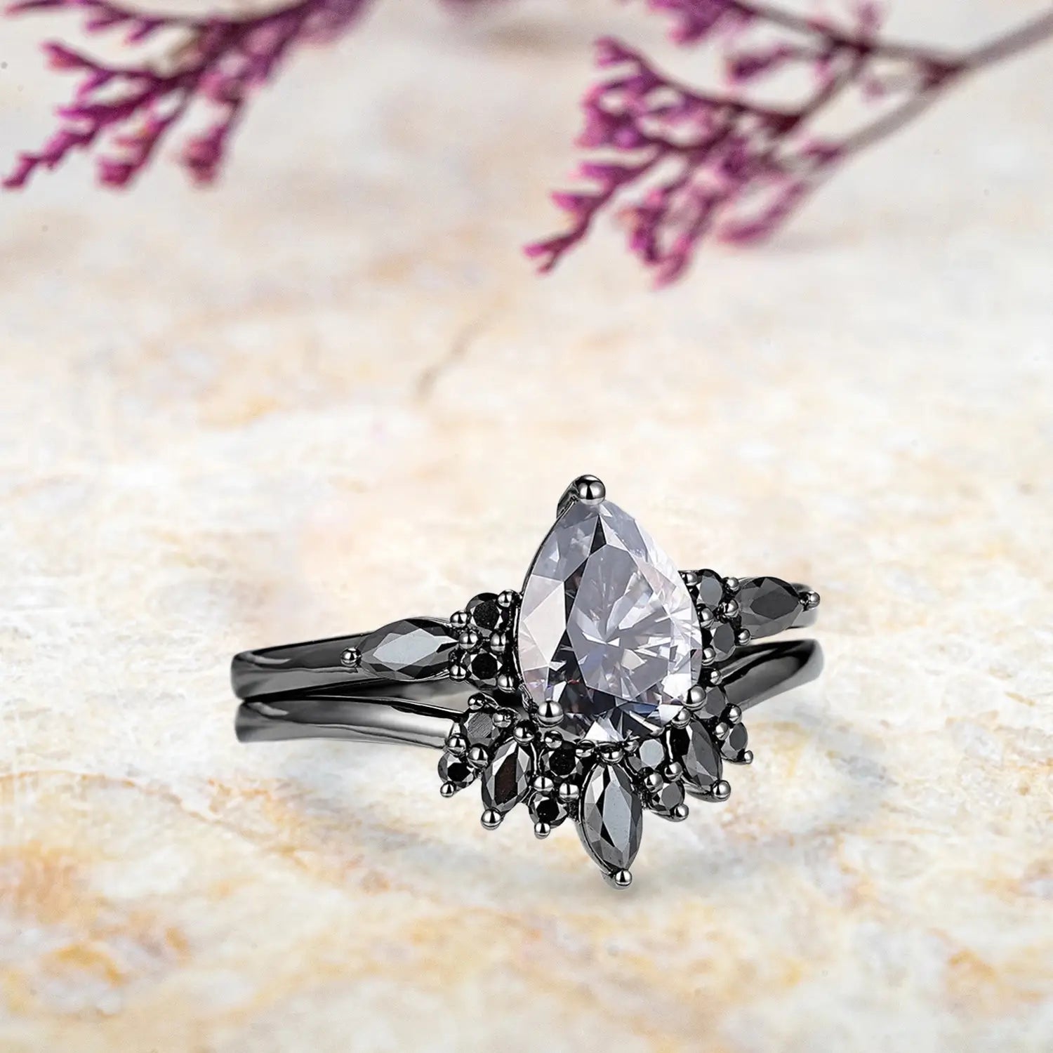 Side view of pear gray moissanite ring showing marquise black moissanite cluster and chevron sunburst band profile