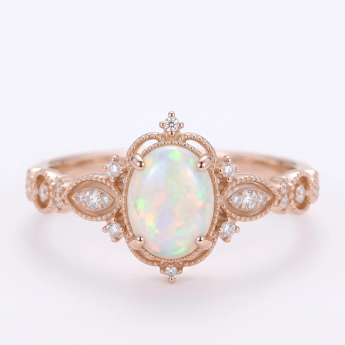 Front view of Iravelle oval white opal engagement ring with rainbow play-of-color, Edwardian milgrain frame and floral openwork rose gold band.