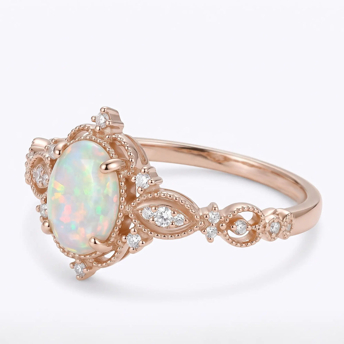 Left angled view of Iravelle vintage white opal ring highlighting its ornate milgrain setting, marquise-shaped filigree and sculpted leaf detailing.