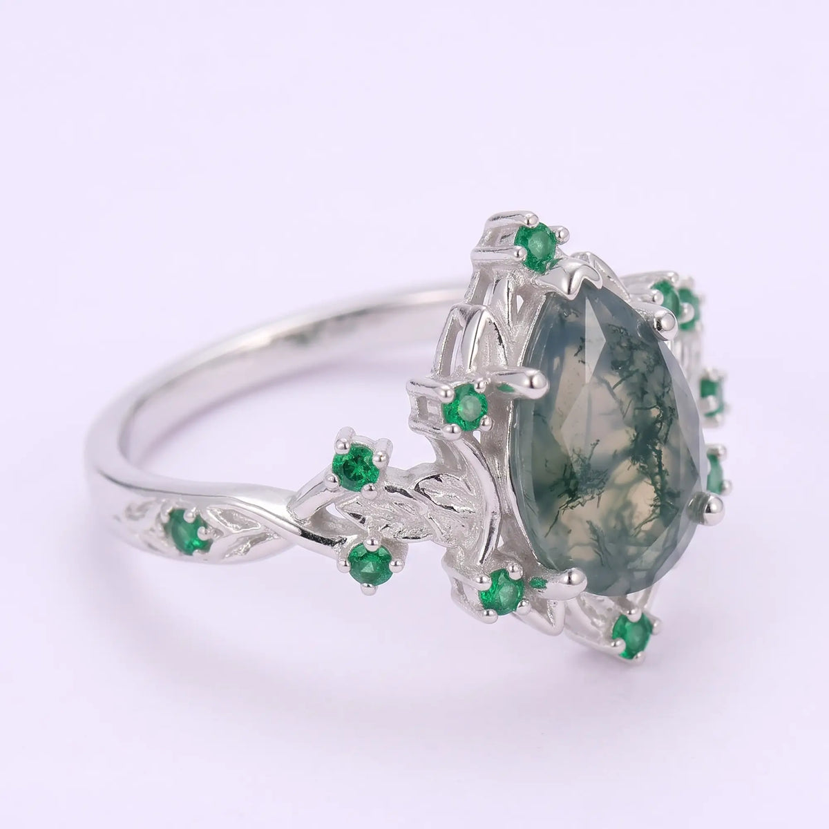 Opposite side angle of Lunavelle nature-inspired moss agate ring highlighting the crescent moon curves, flowing leaf filigree and delicate openwork gold shoulders.