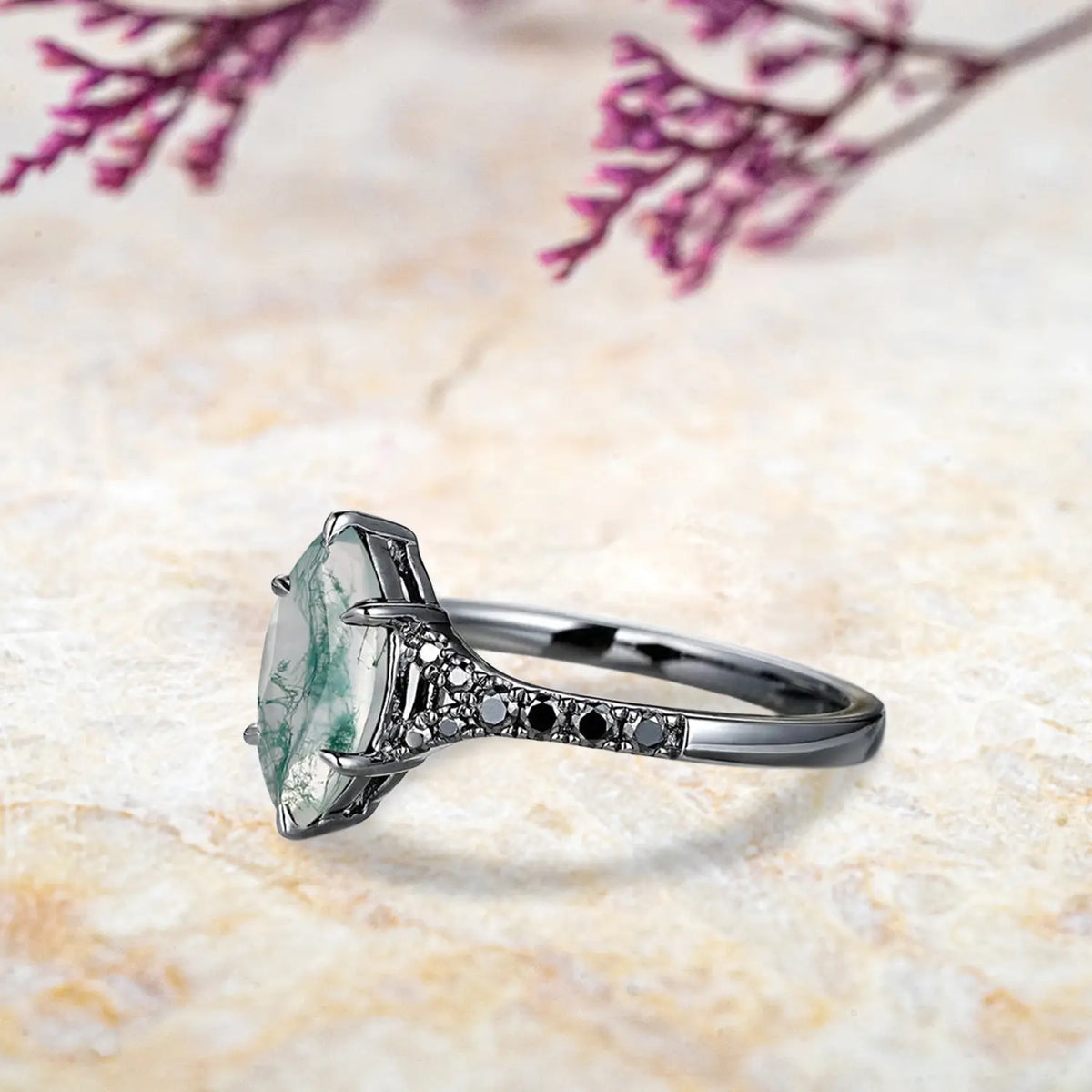 Close up detail of marquise moss agate center stone with unique green inclusions in split shank setting