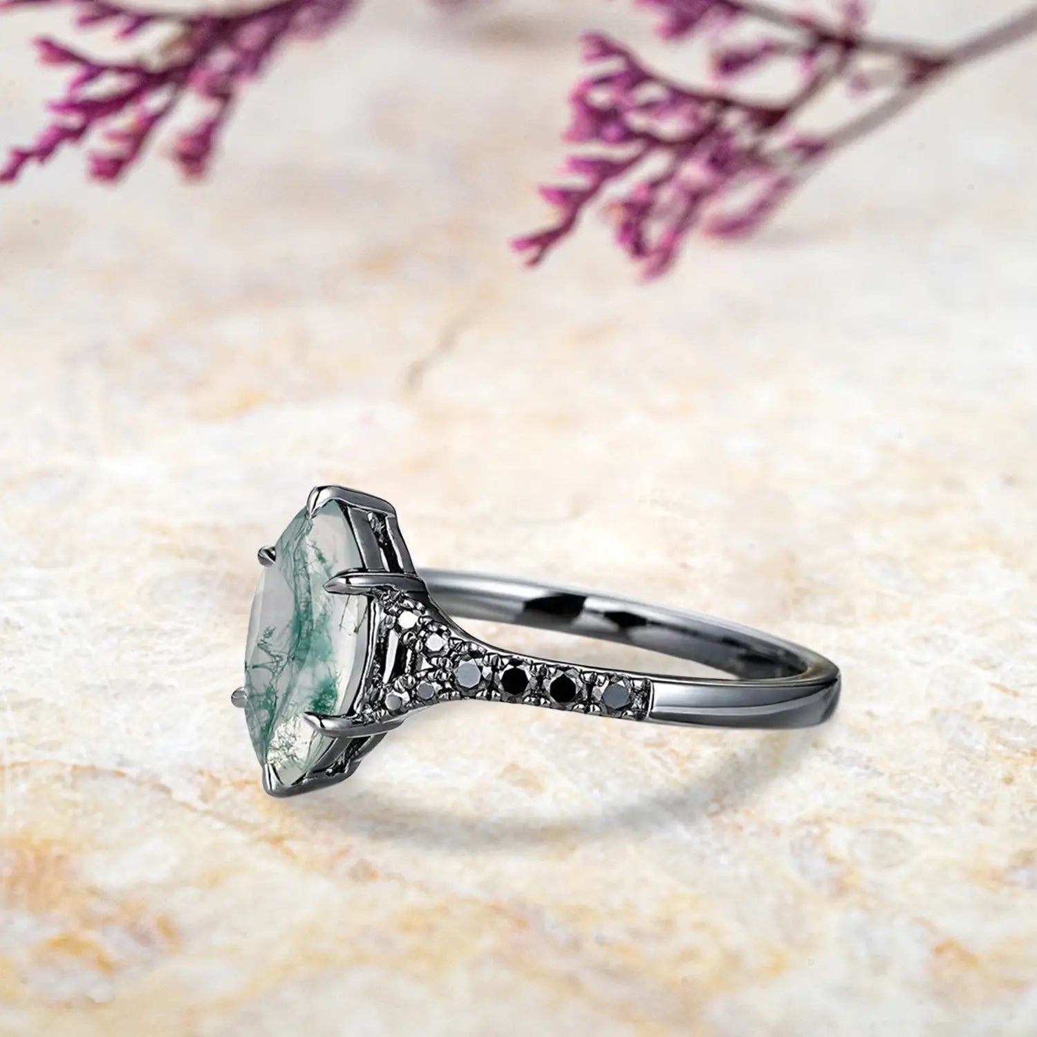 Close up detail of marquise moss agate center stone with unique green inclusions in split shank setting