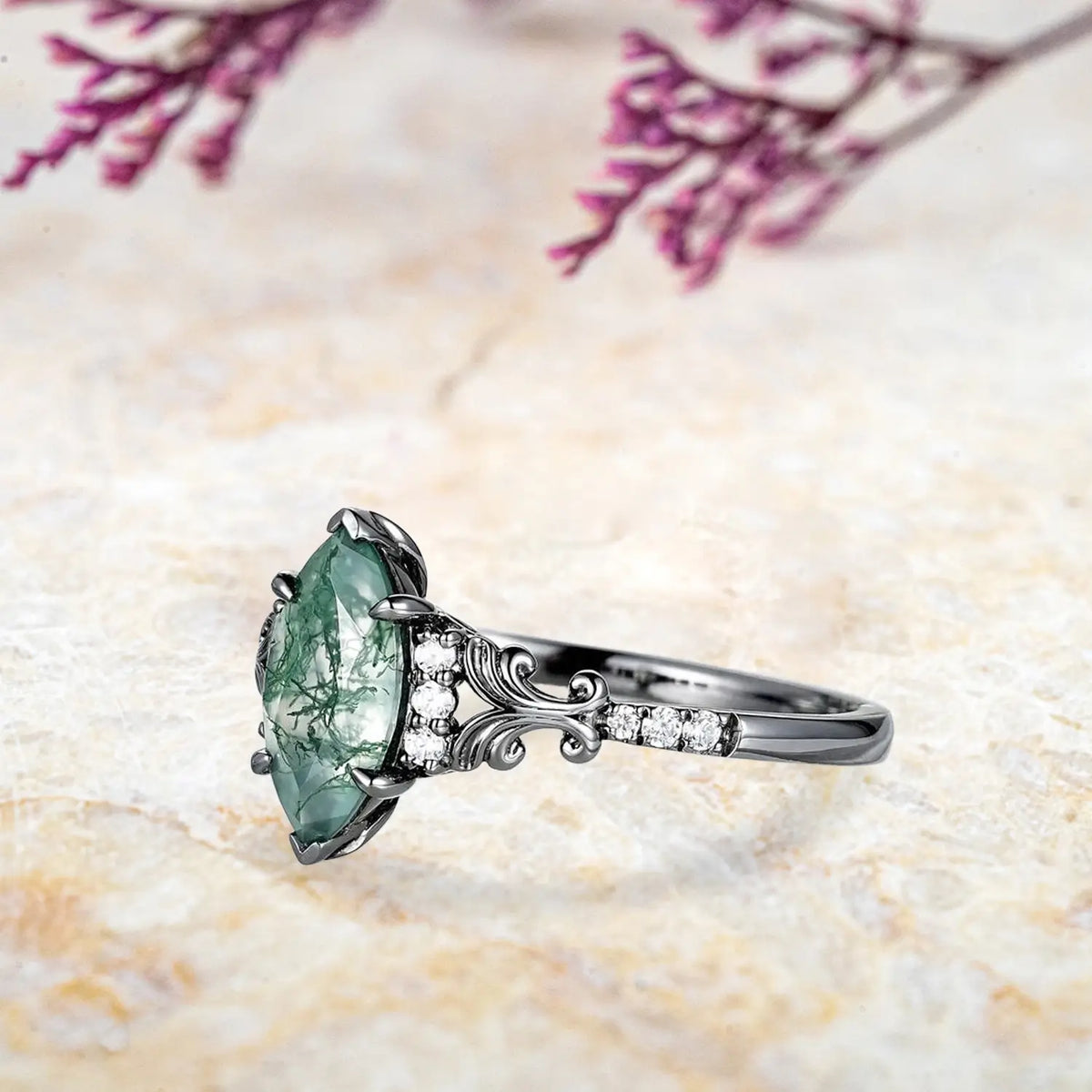 Side view of vintage moss agate engagement ring showing ornate scrollwork and moissanite accents