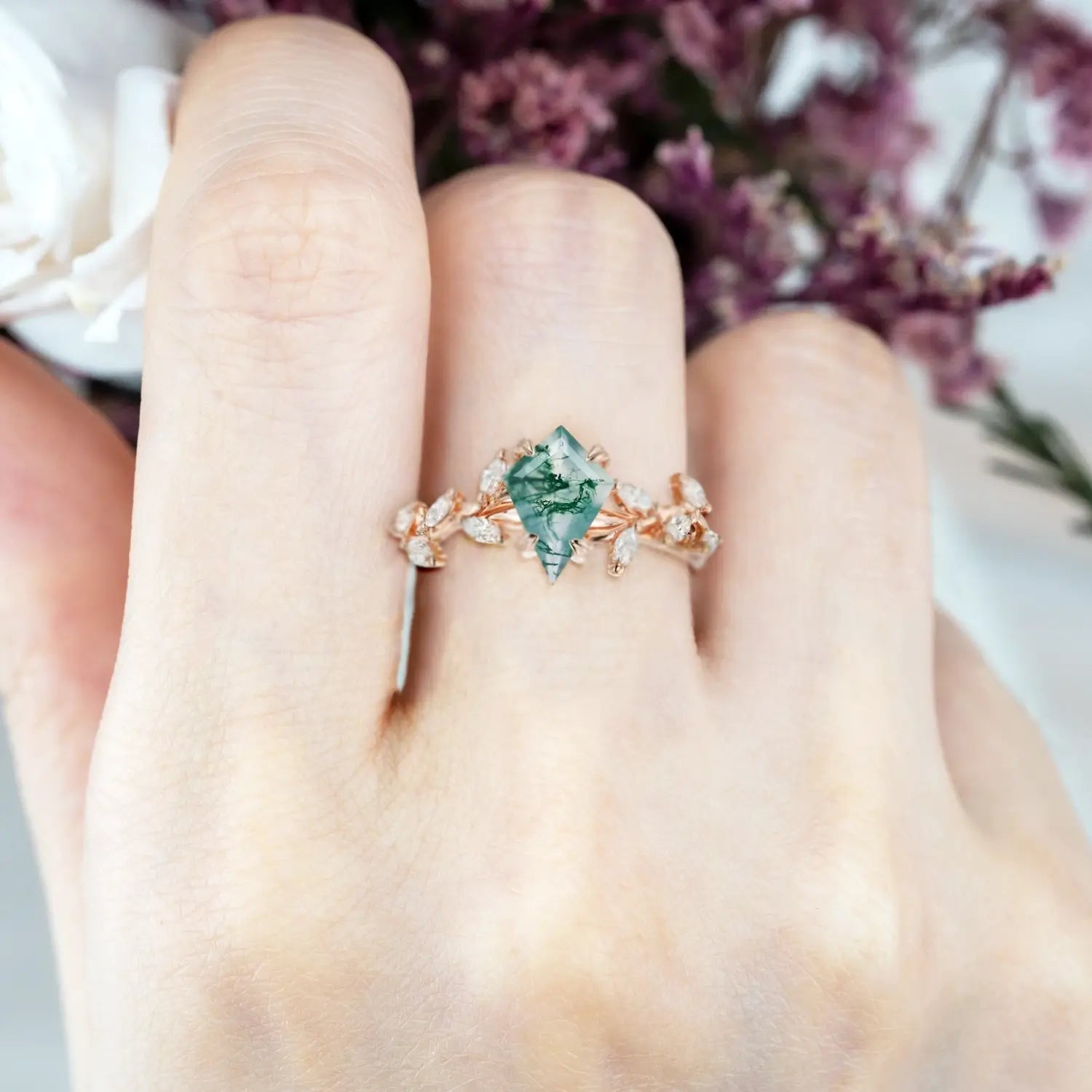 Woman wearing kite moss agate rose gold engagement ring with leaf cluster design