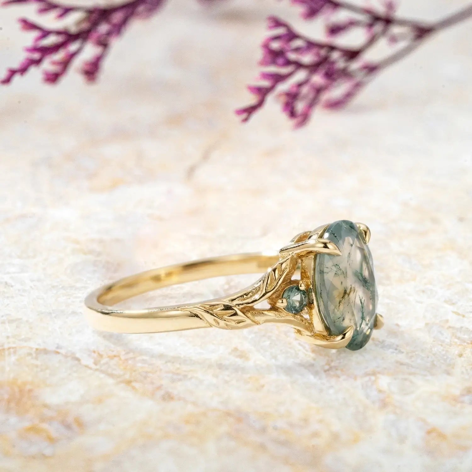 Side view of oval moss agate engagement ring with leaf band