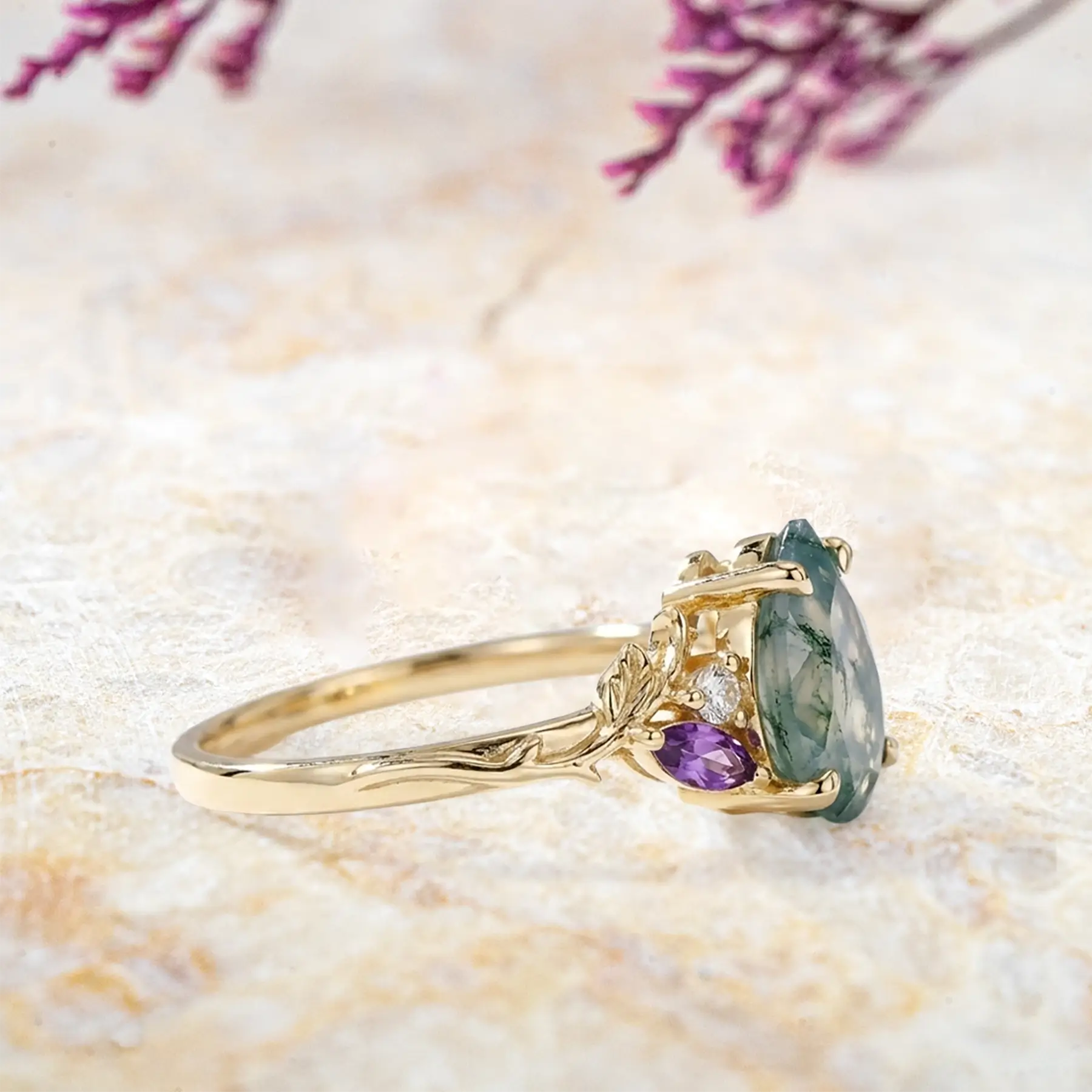 Side view of pear moss agate engagement ring with moissanite and amethyst