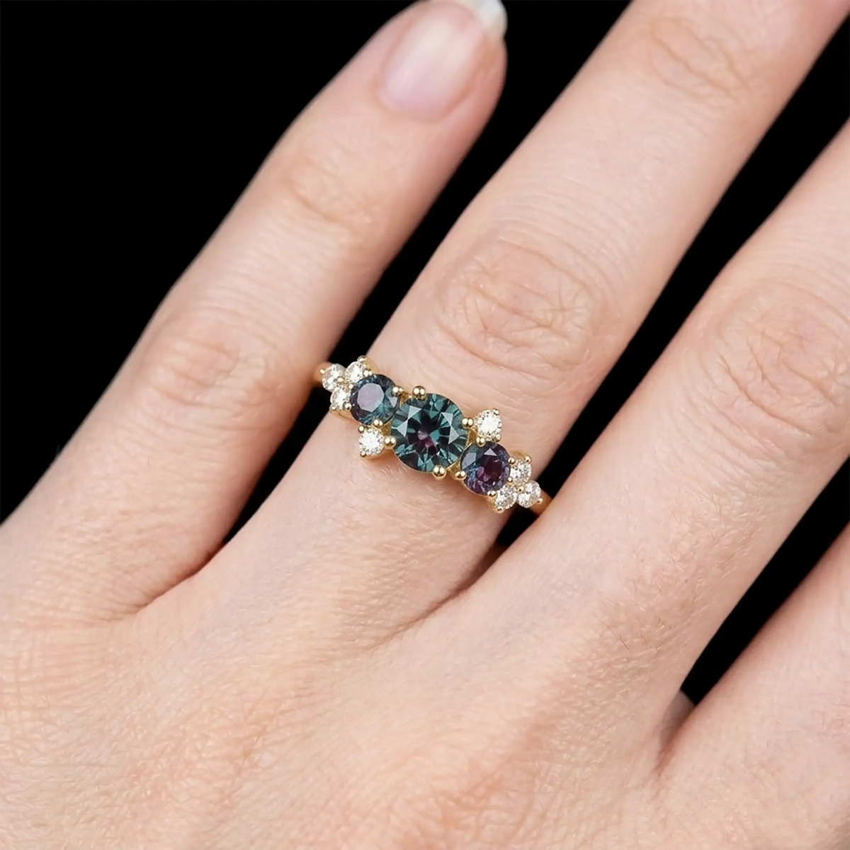 Luminous handmade June birthstone alexandrite ring on hand showing deep teal color change