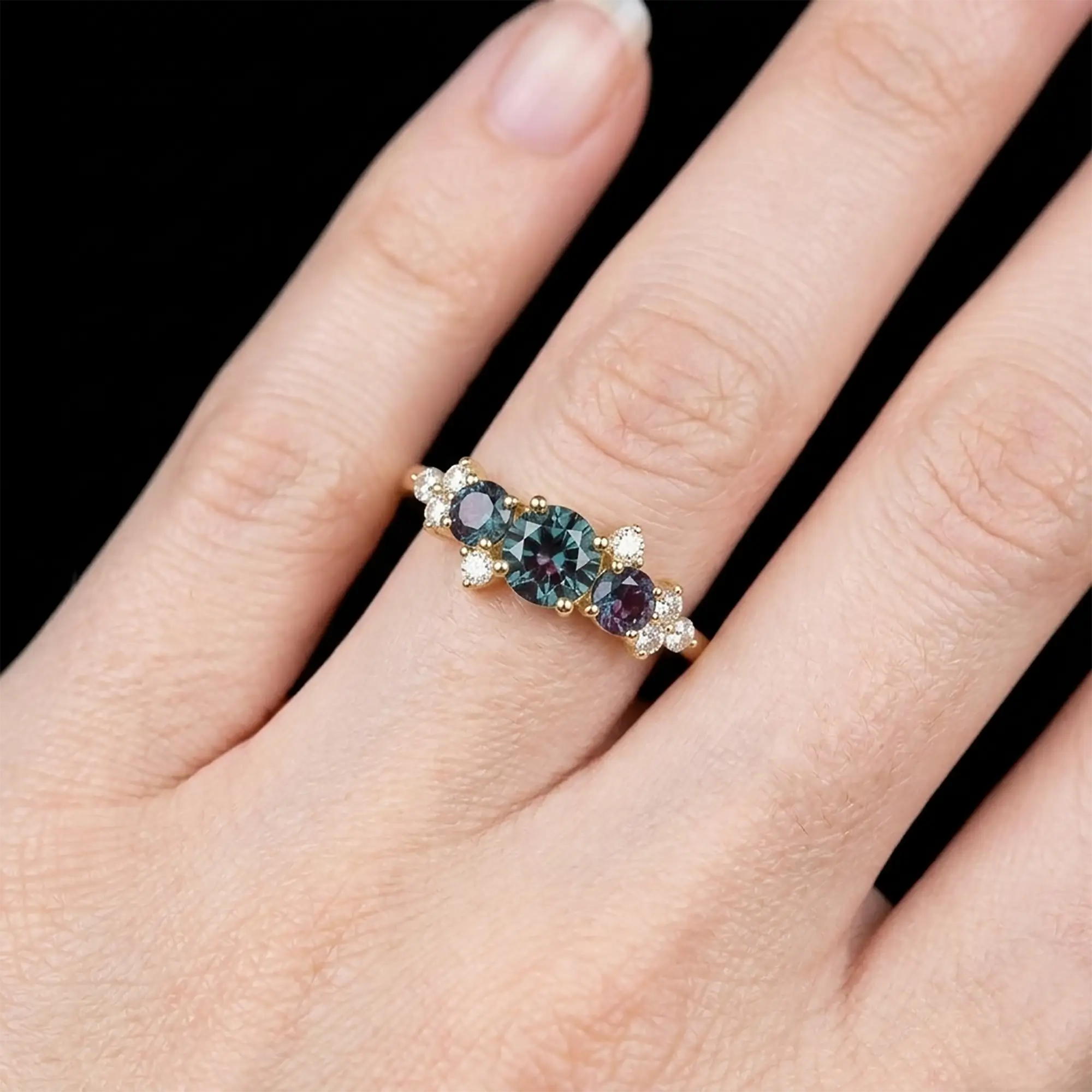Luminous handmade June birthstone alexandrite ring on hand showing deep teal color change