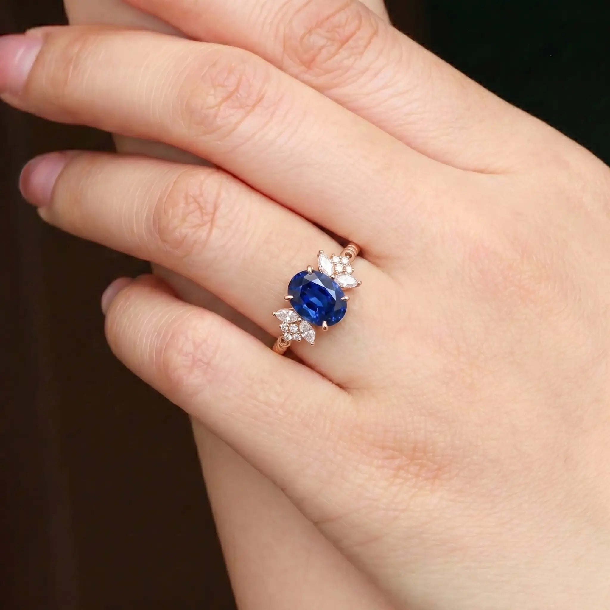 Luminous handmade September birthstone sapphire ring on hand showing intricate twisted gold craftsmanship