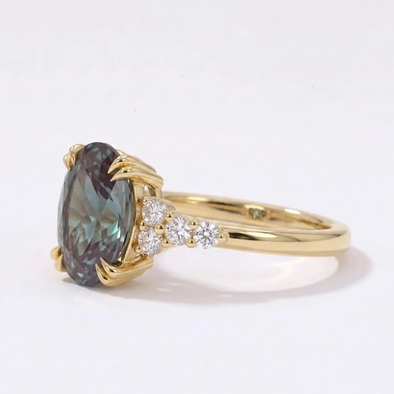 Detailed macro photo of an 8x6mm oval lab alexandrite showing vivid pleochroic color shifts and secure double-prong craftsmanship