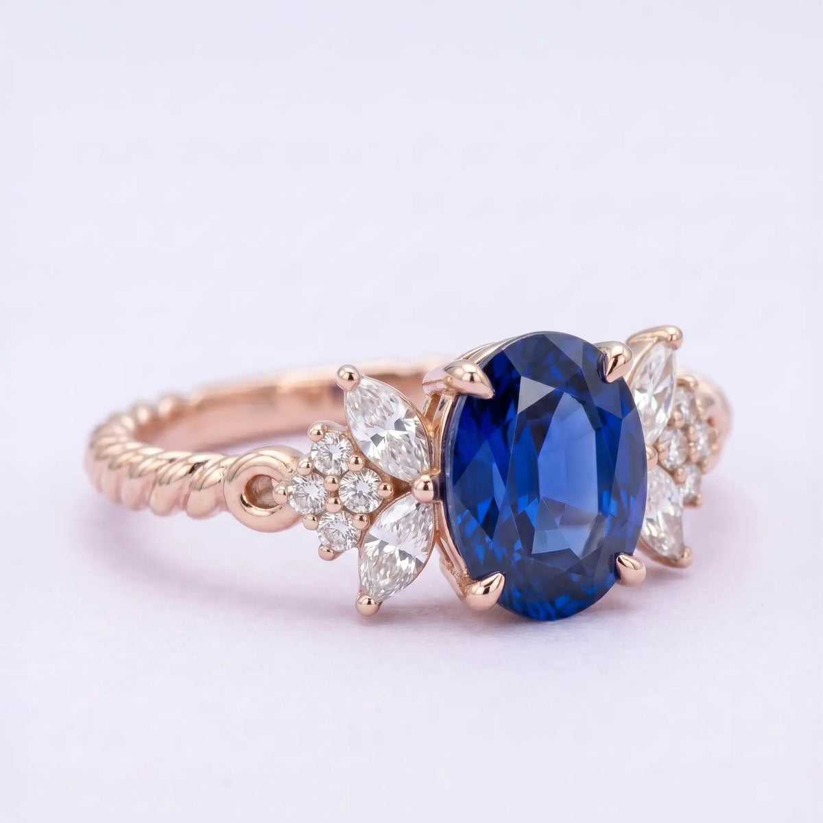Unique alternative bridal sapphire ring with marquise and round moissanite cluster side stones