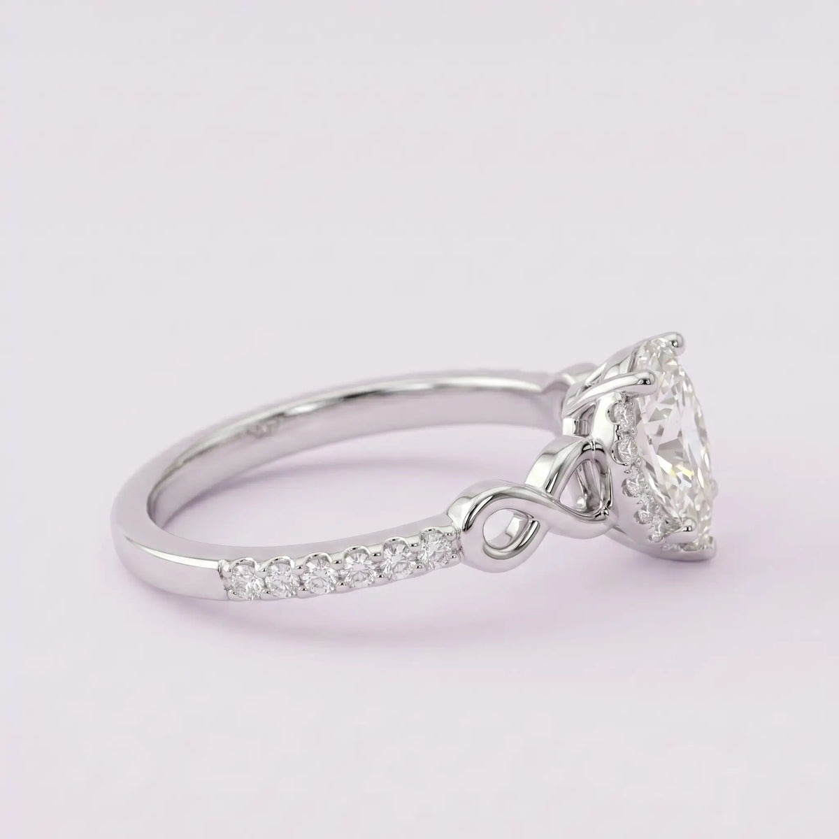 Side view profile of alternative bridal pear moissanite ring highlighting low-profile halo setting
