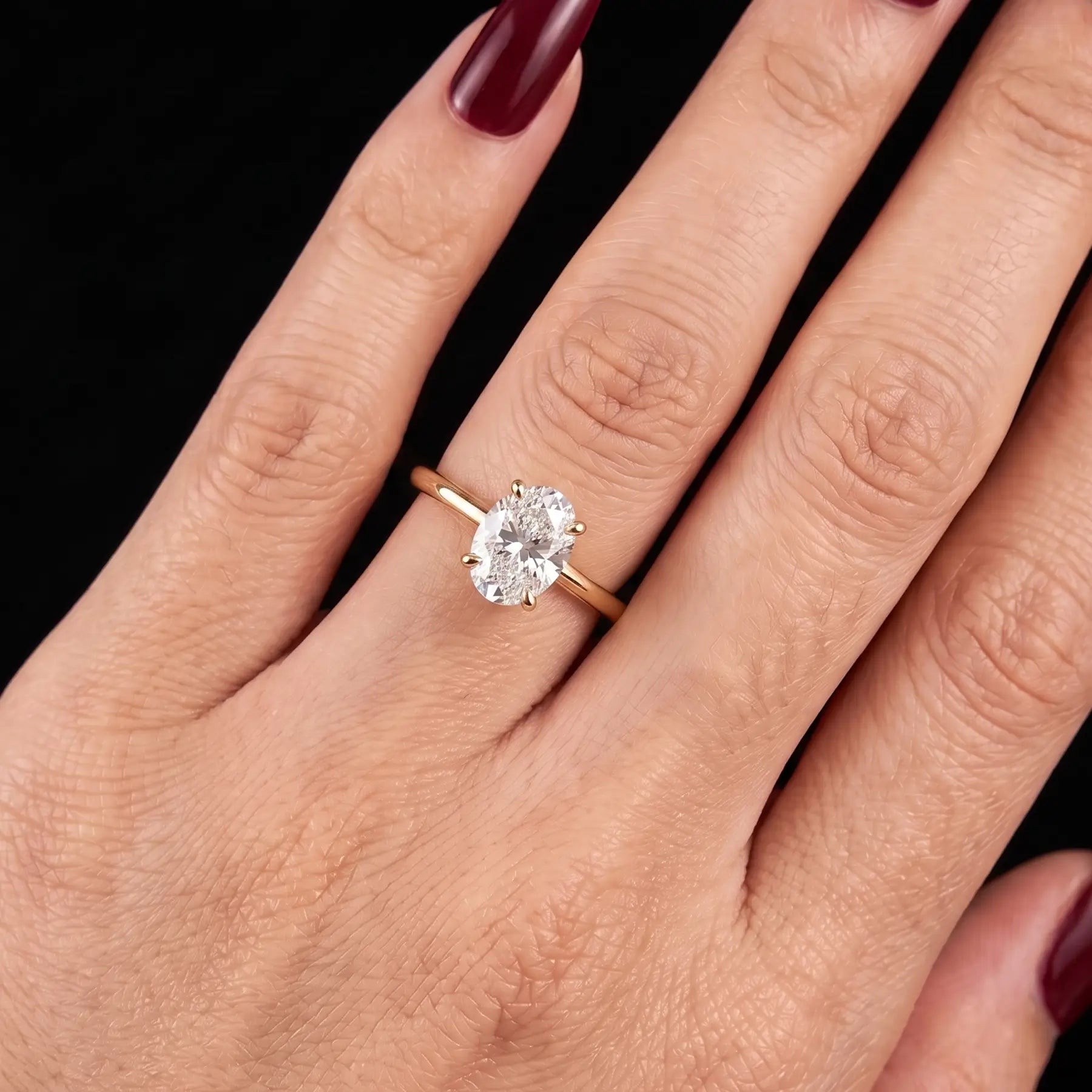 Oval lab diamond solitaire engagement ring worn on hand for an elongated elegant look