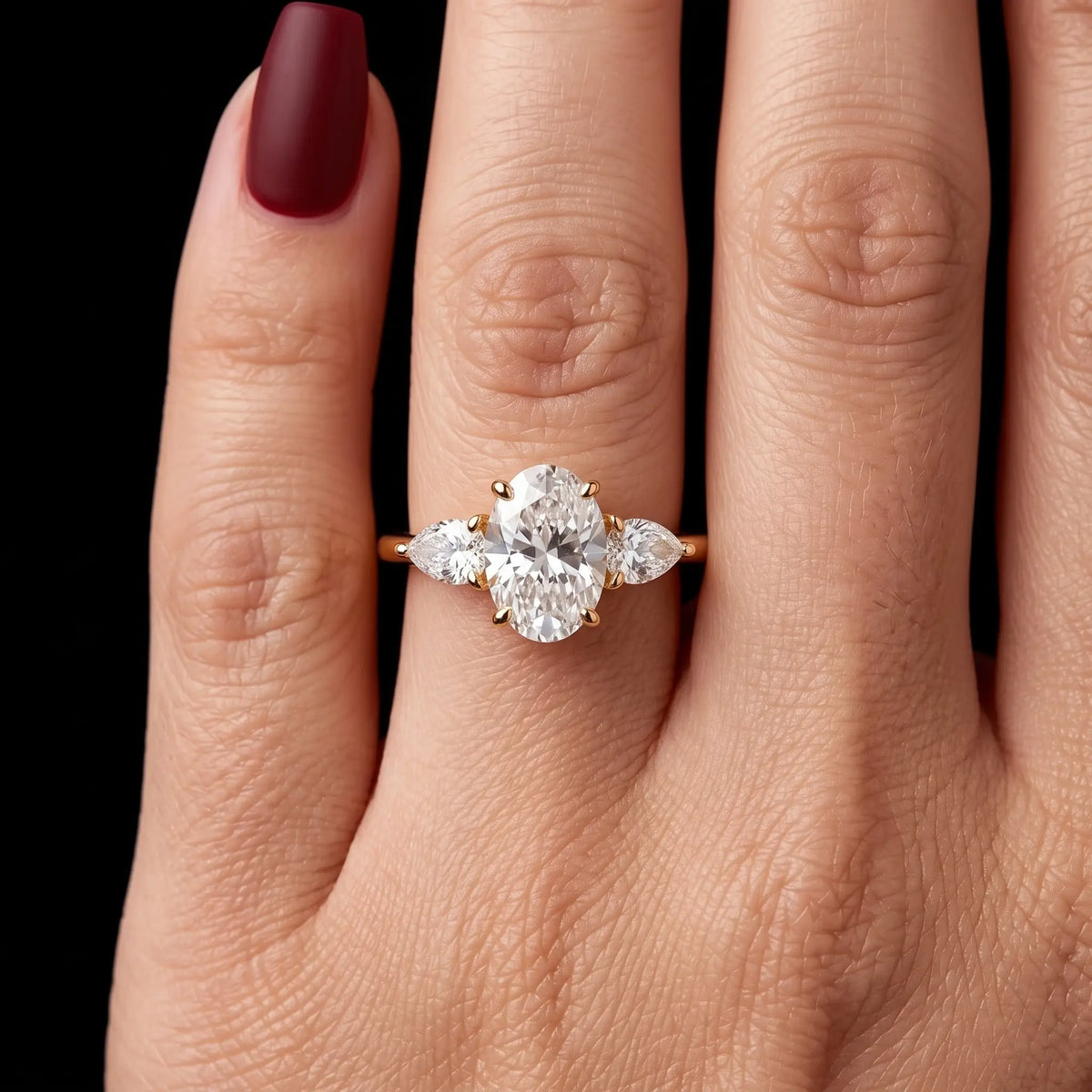 Oval moissanite three stone engagement ring worn on hand with minimalist gold design