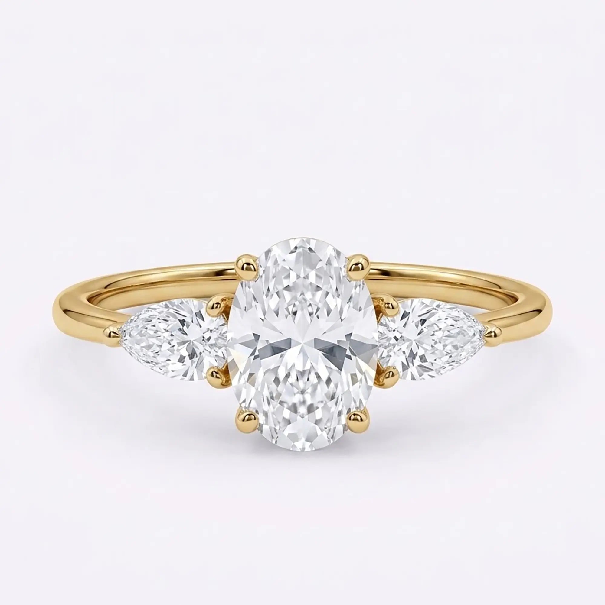 Classic oval moissanite three stone engagement ring with pear side stones in yellow gold