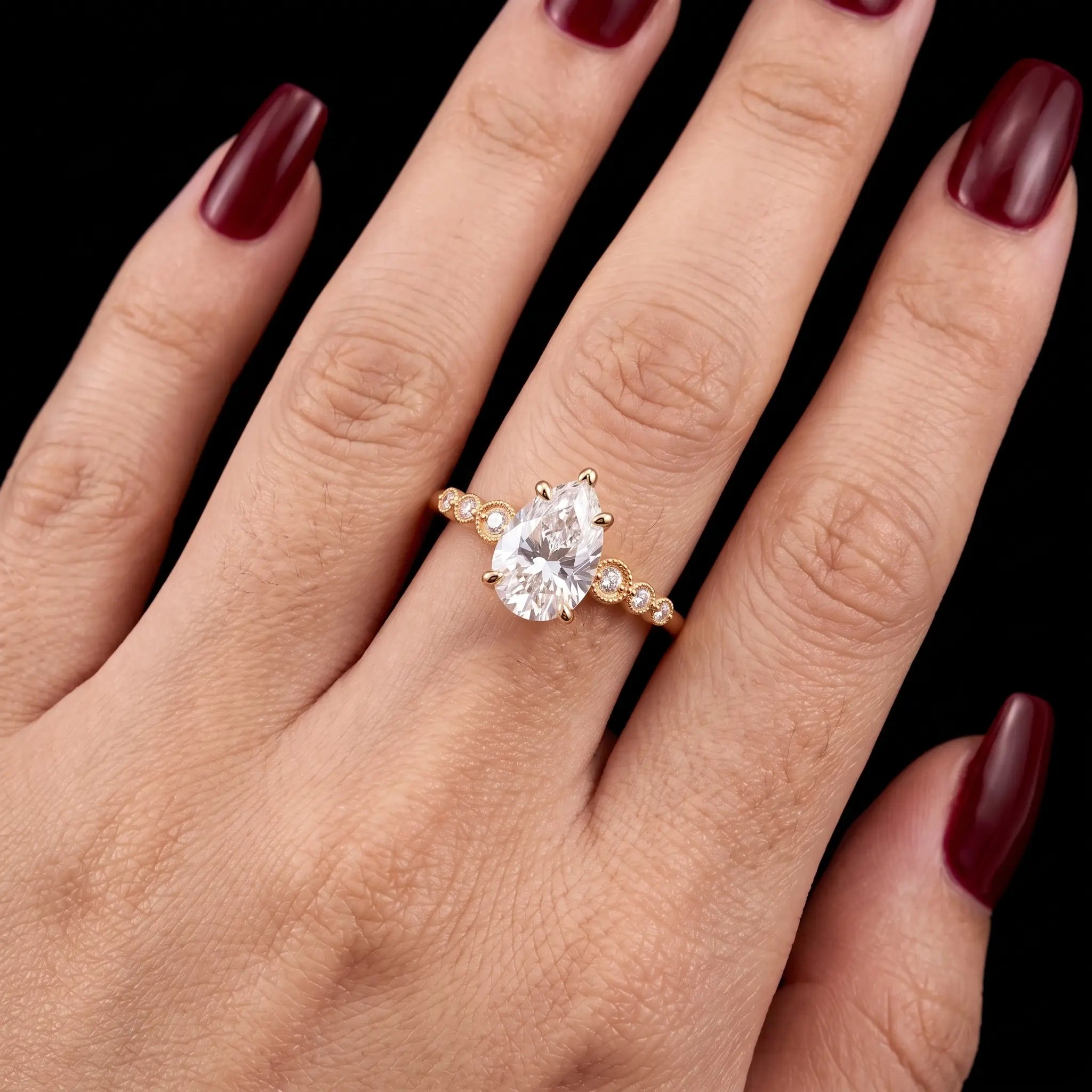 Pear cut moissanite seven stone engagement ring worn on hand for an elegant elongated look