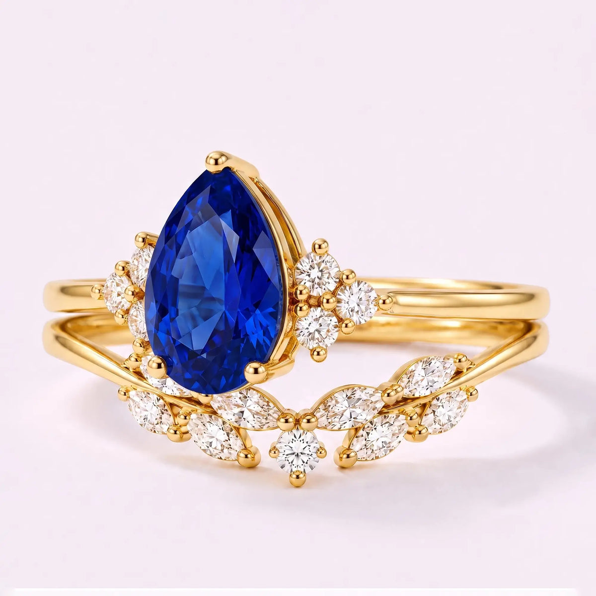 Left view of pear sapphire bridal ring set with moissanite cluster accents and curved band