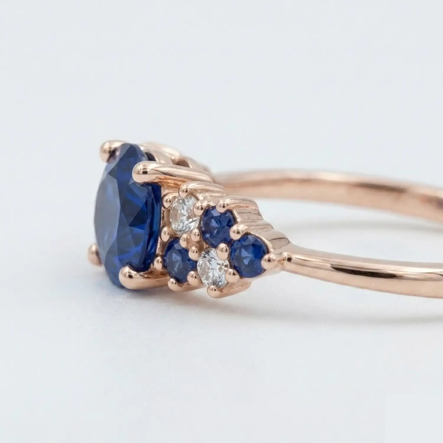 Artisanal gold cluster ring featuring round sapphire and brilliant moissanite mosaic.