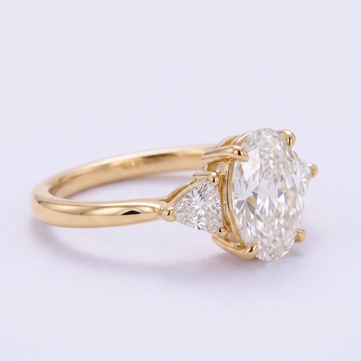 Alternate angle of classic three stone engagement ring with oval center moissanite