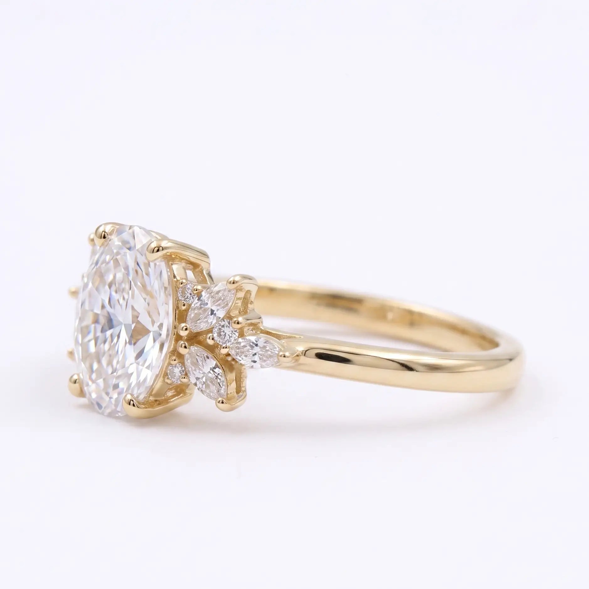 Leaf view of an oval moissanite cluster engagement ring with symmetrical marquise side accents