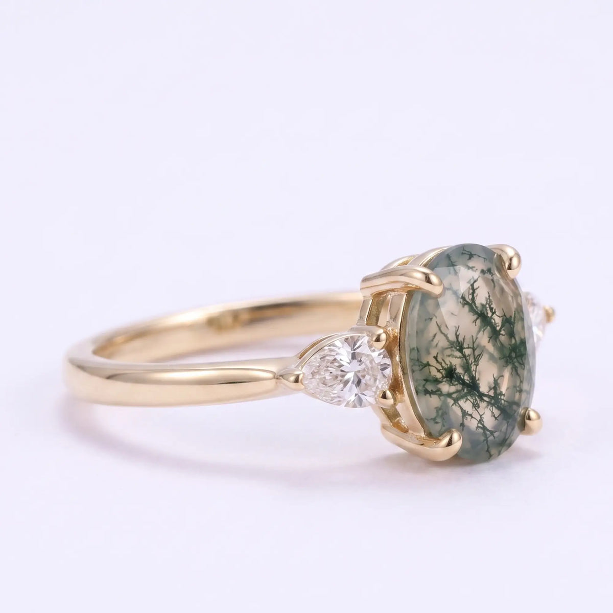 Front view of minimalist oval moss agate three stone engagement ring