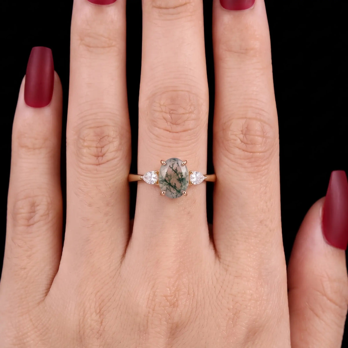 Oval moss agate three stone ring worn on hand for engagement or anniversary styling