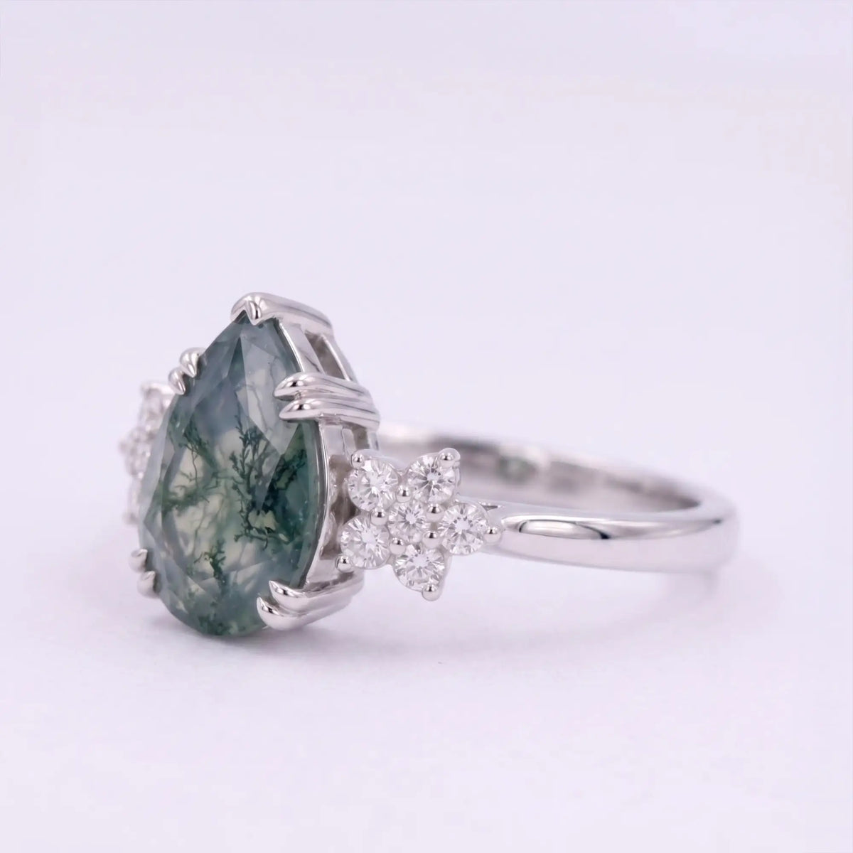 Side view profile of alternative bridal pear moss agate ring highlighting low-profile stone setting