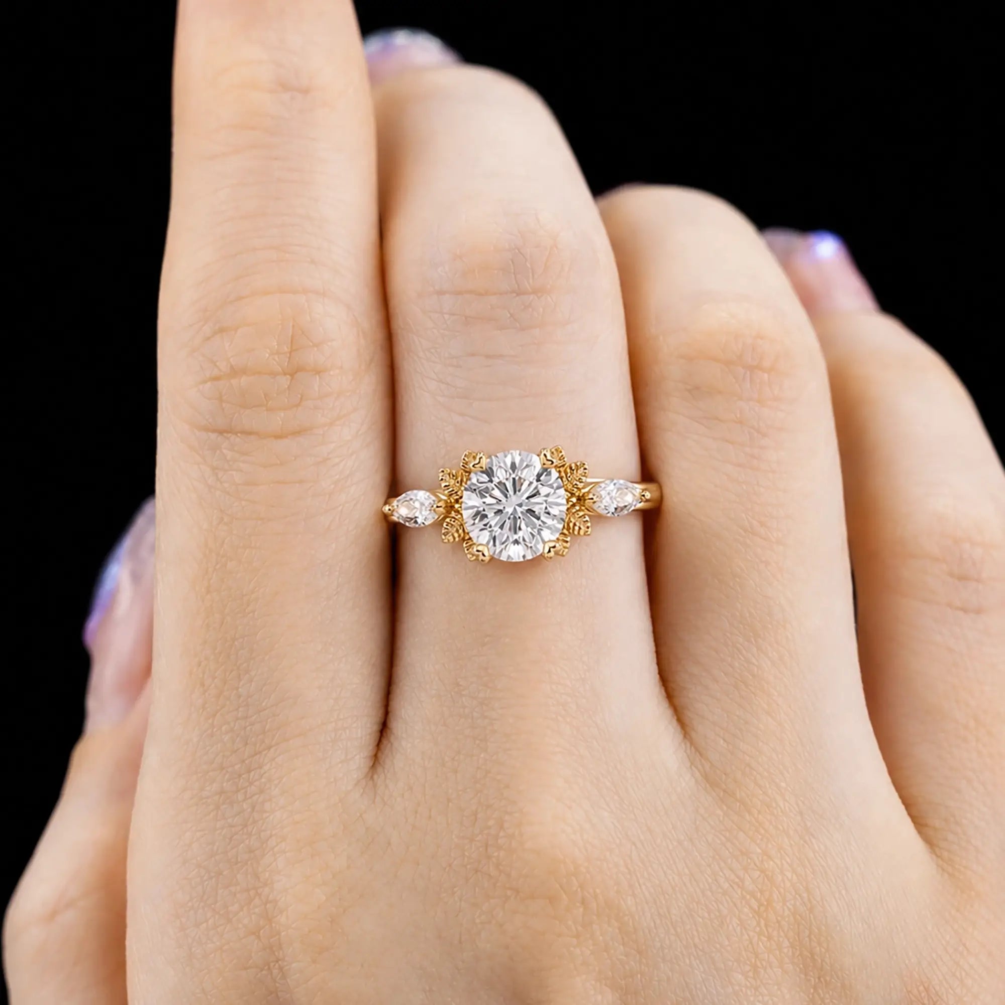 Round moissanite leaf engagement ring worn on hand with elegant three-stone design