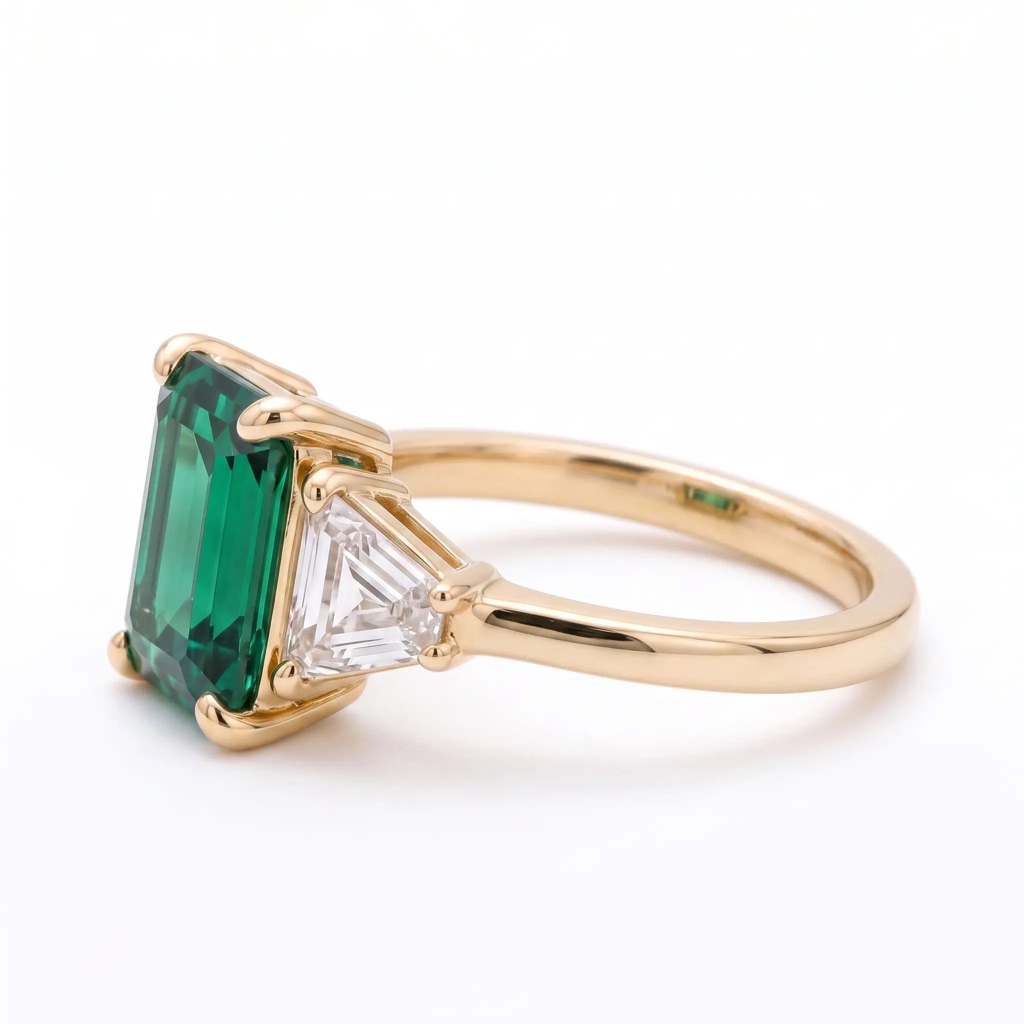 Left view of emerald cut emerald ring with trapezoid side stones
