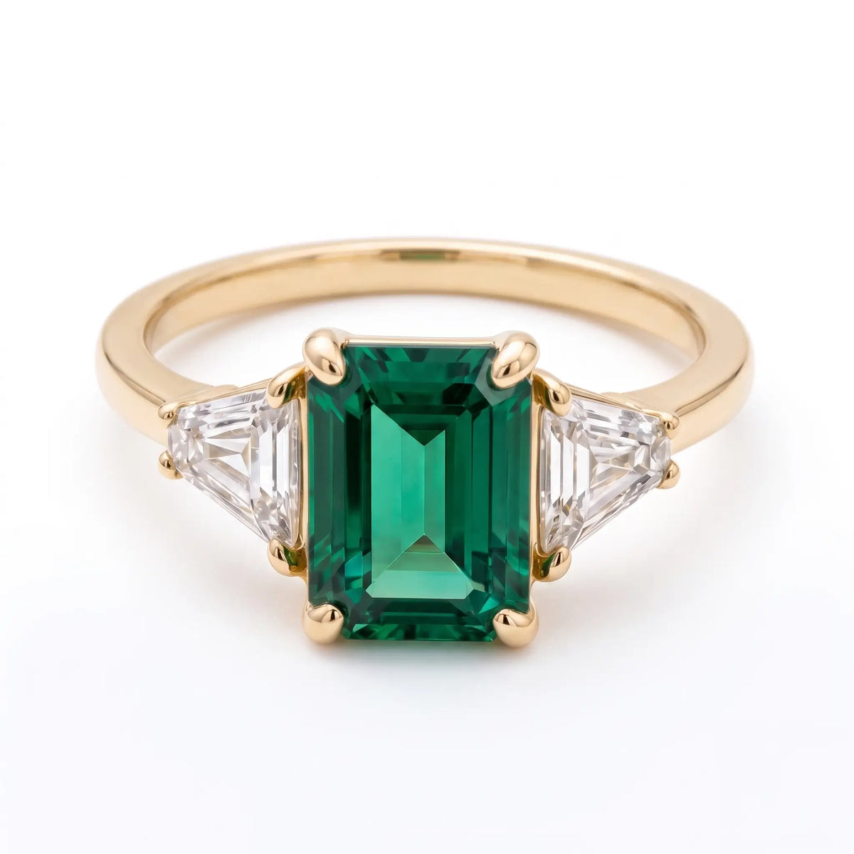 Classic emerald cut emerald three stone engagement ring in yellow gold