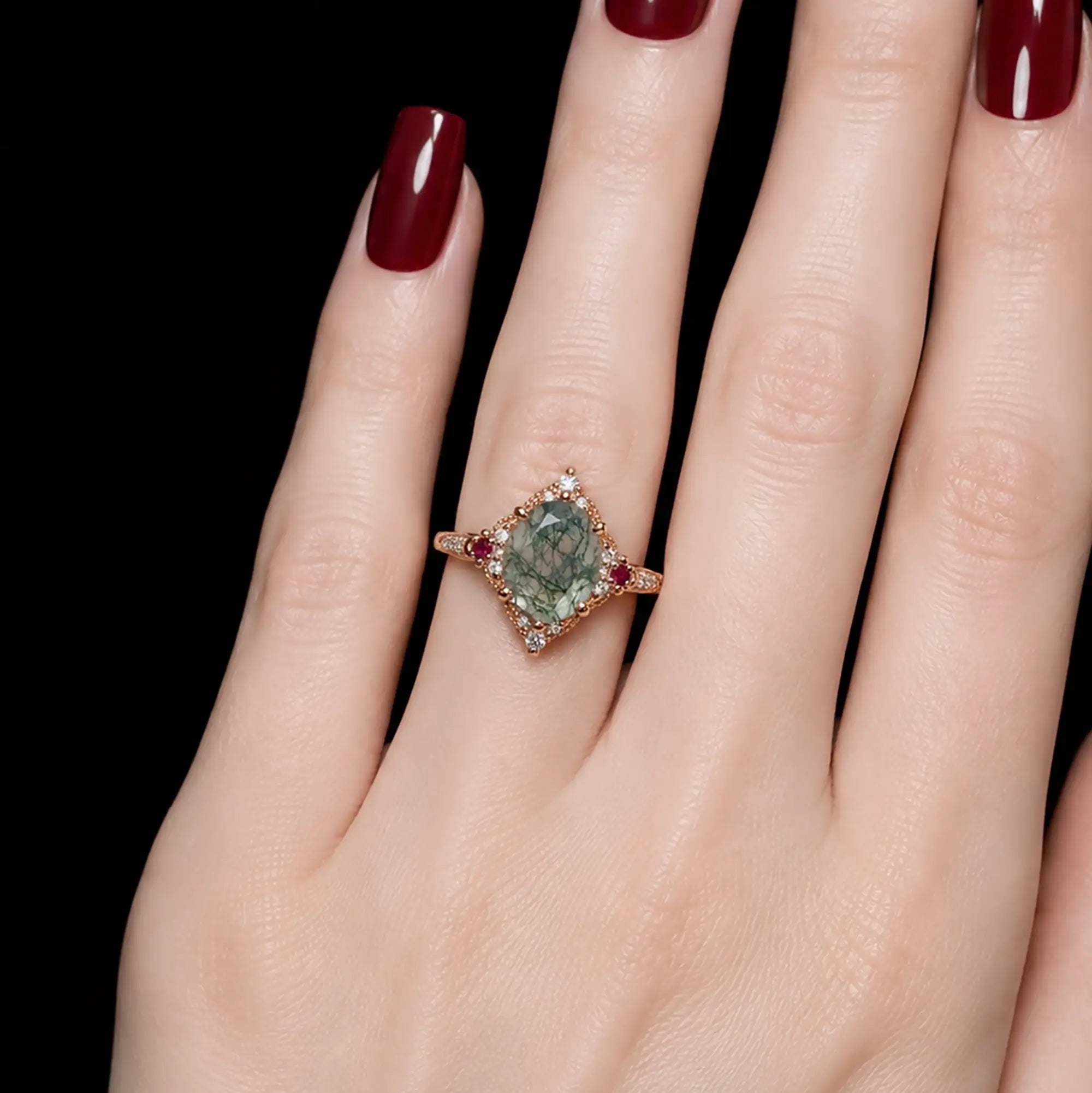 Oval moss agate halo engagement ring worn on hand with classic vintage design