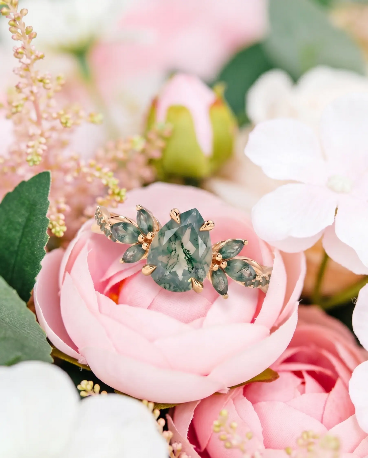 Nature-inspired moss agate engagement ring styled in a soft romantic scene