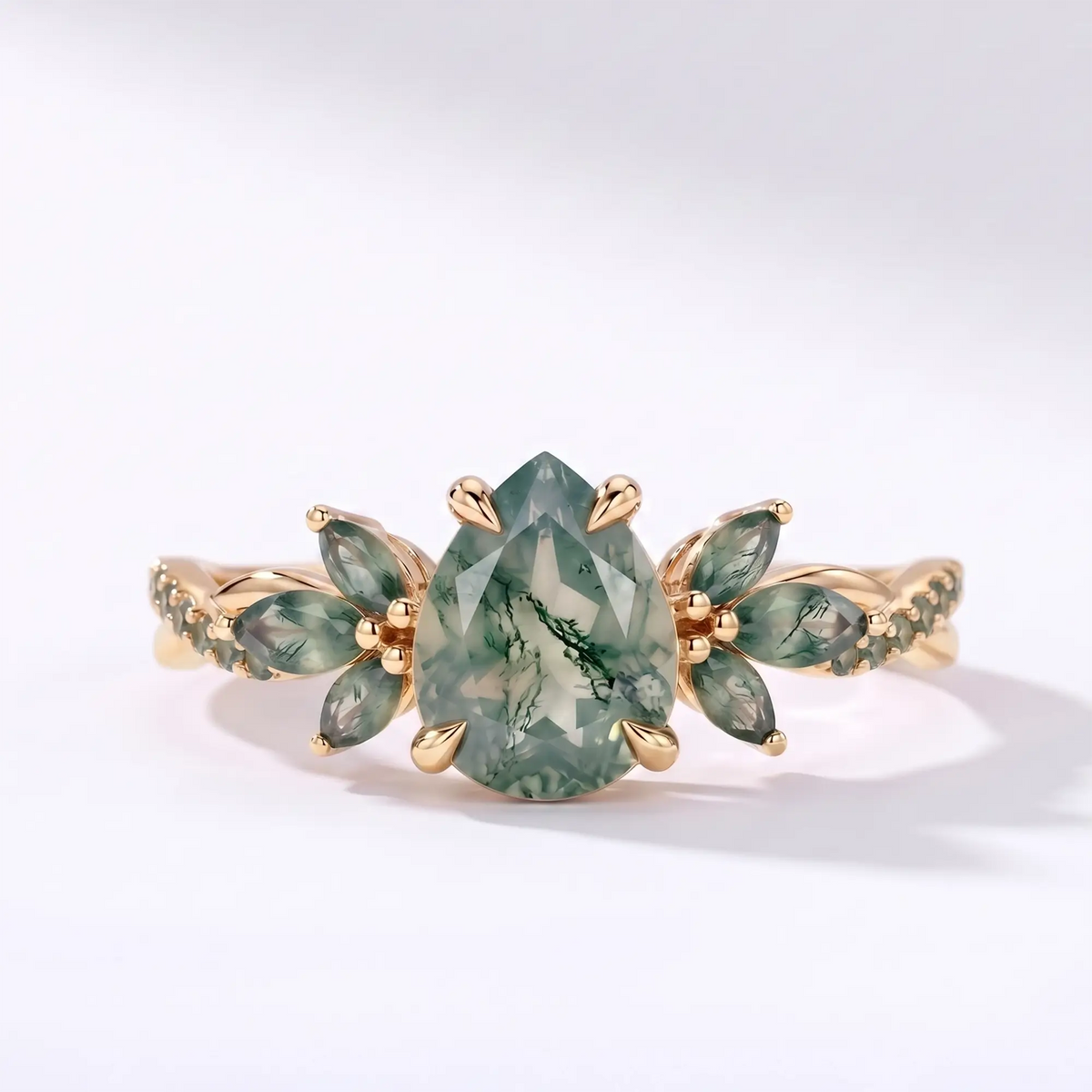 Pear moss agate engagement ring with a twisted floral band in yellow gold
