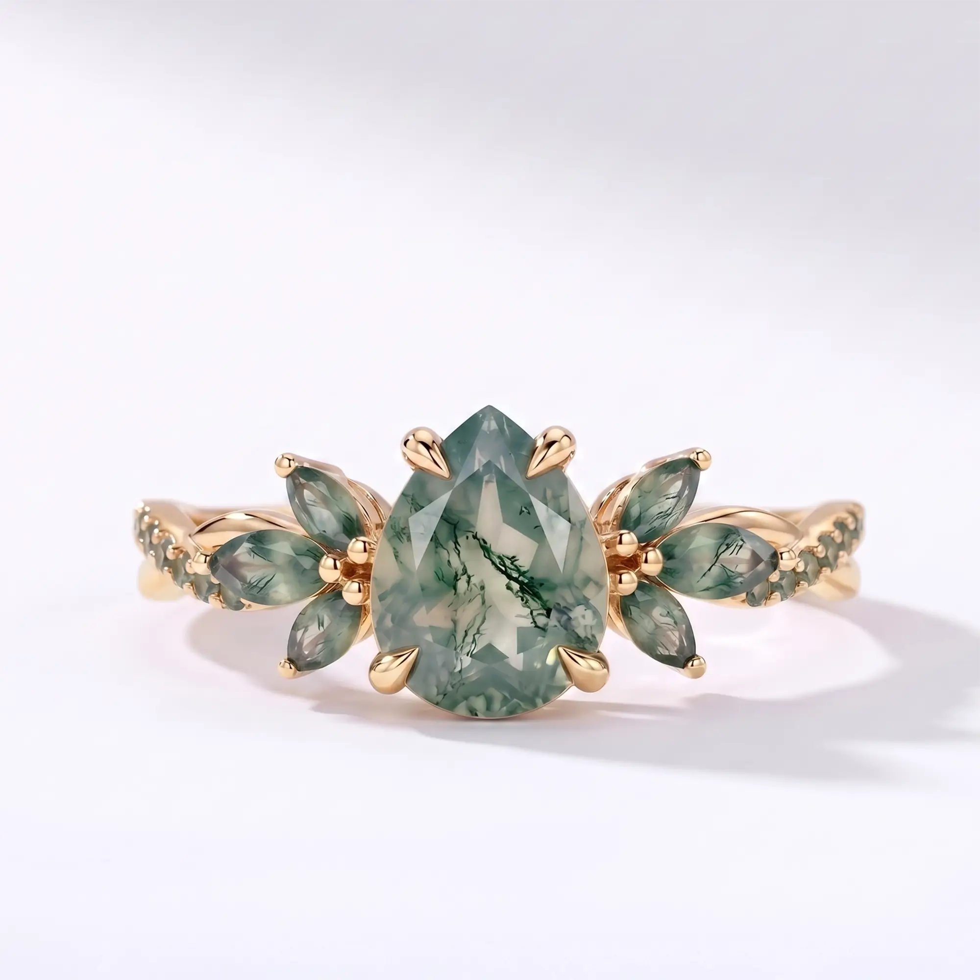 Pear moss agate engagement ring with a twisted floral band in yellow gold