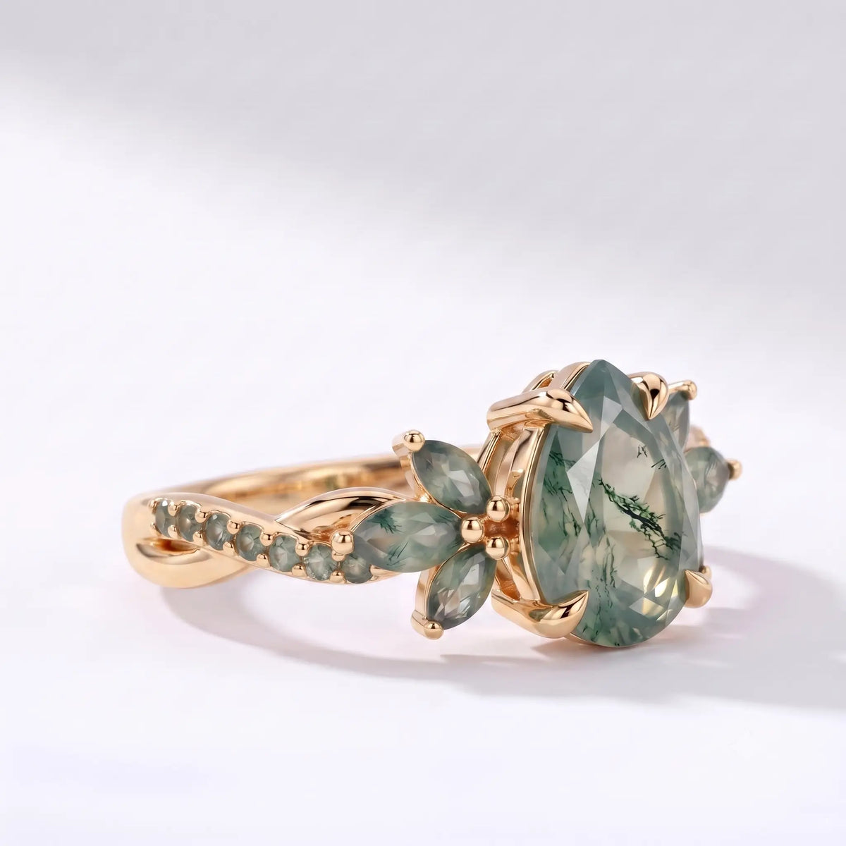 Side profile of pear moss agate engagement ring with raised prong setting