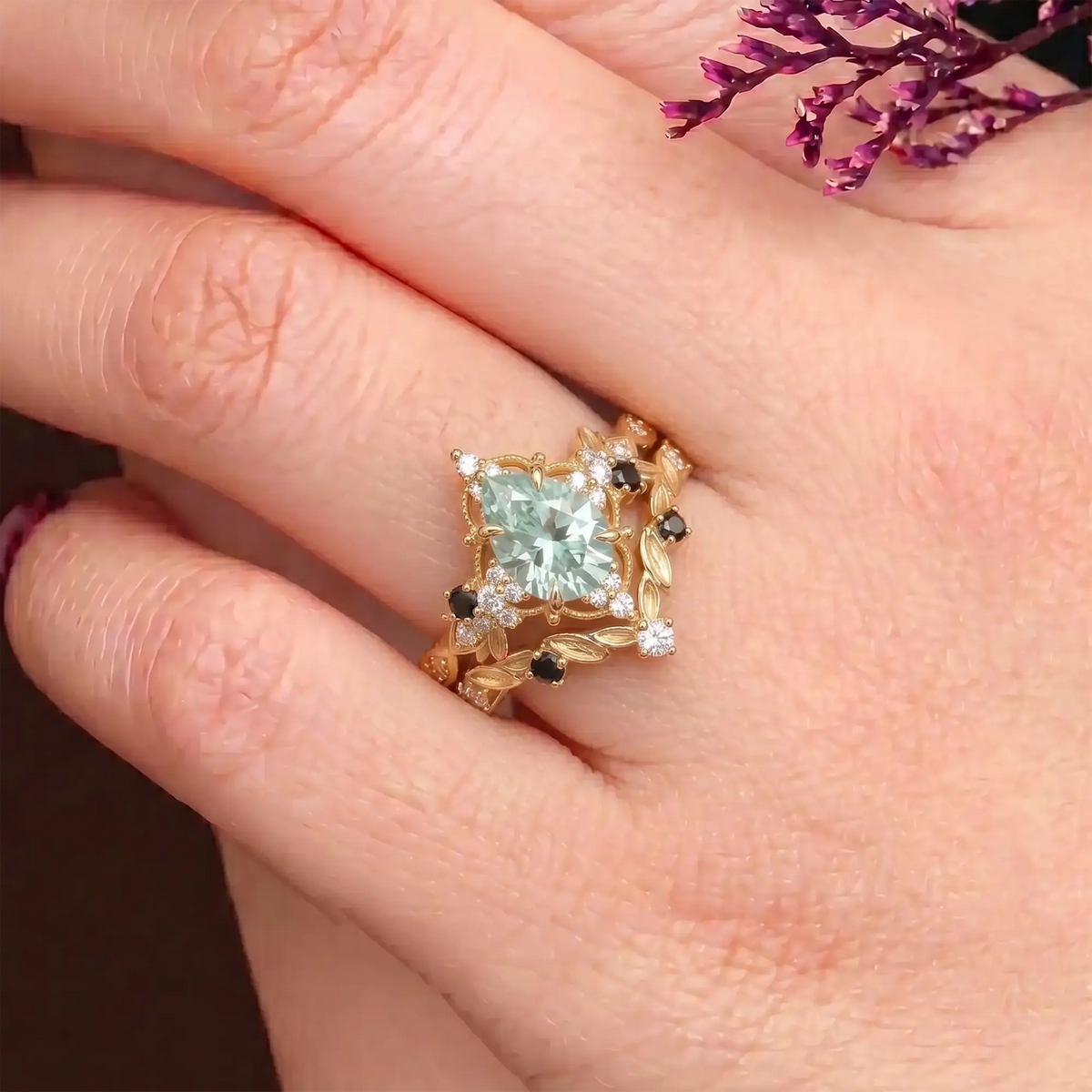Unique high-contrast grey moissanite and black onyx cluster bridal set shown stacked together on a woman's finger
