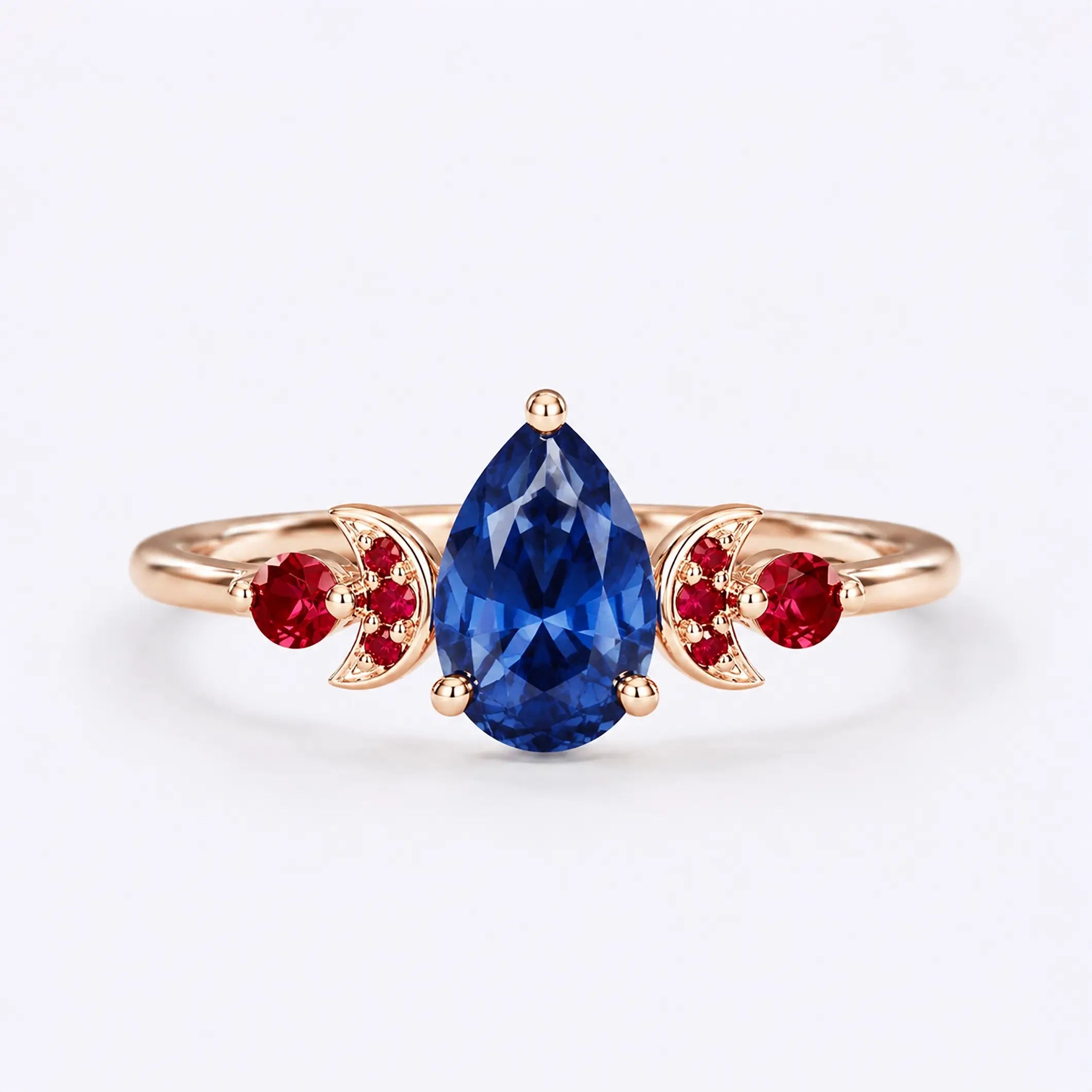 Pear cut sapphire engagement ring with ruby crescent moon accents in rose gold