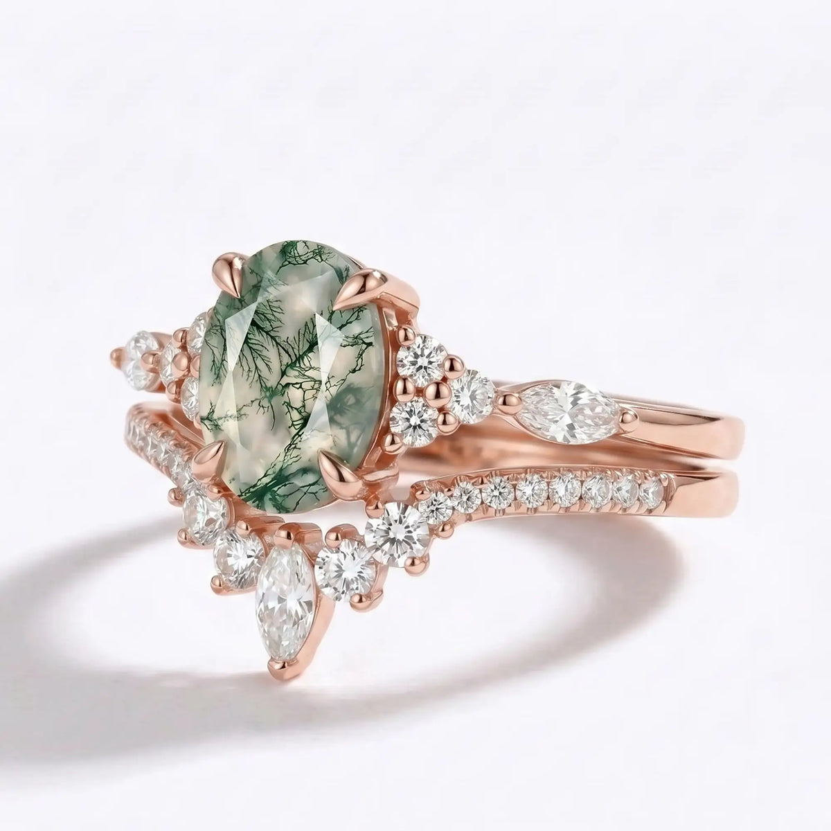 Close-up of solid gold cluster ring featuring an oval natural moss agate center stone and brilliant moissanite accents