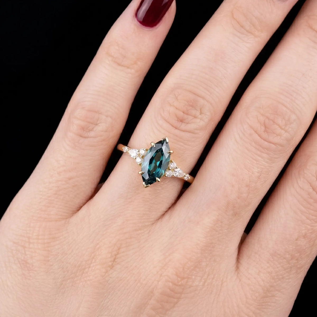 Alternative bridal marquise alexandrite cluster ring in rose gold shown worn on a woman's finger