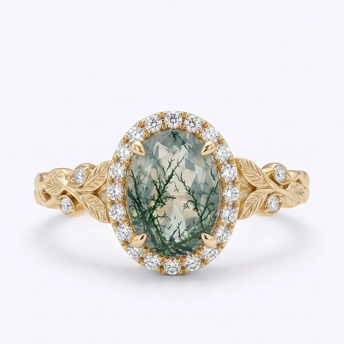 Oval moss agate halo engagement ring with botanical leaf details in yellow gold