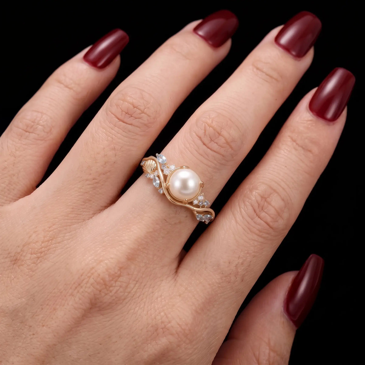 Akoya pearl engagement ring worn on hand with aquamarine and amethyst accents