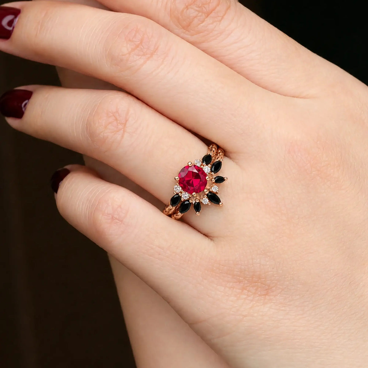 Round ruby engagement ring set worn on hand with matching black onyx band