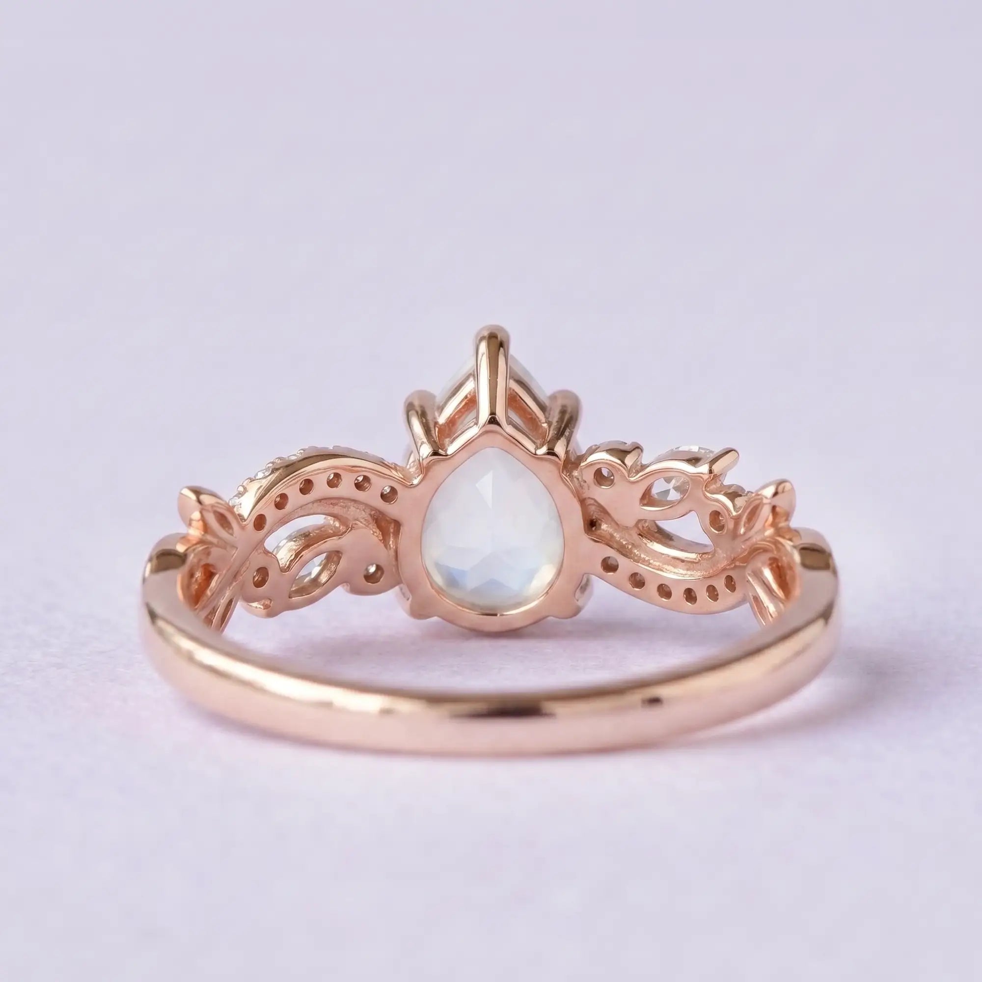Macro close-up of a 6x8mm pear cut natural moonstone with secure prong back view