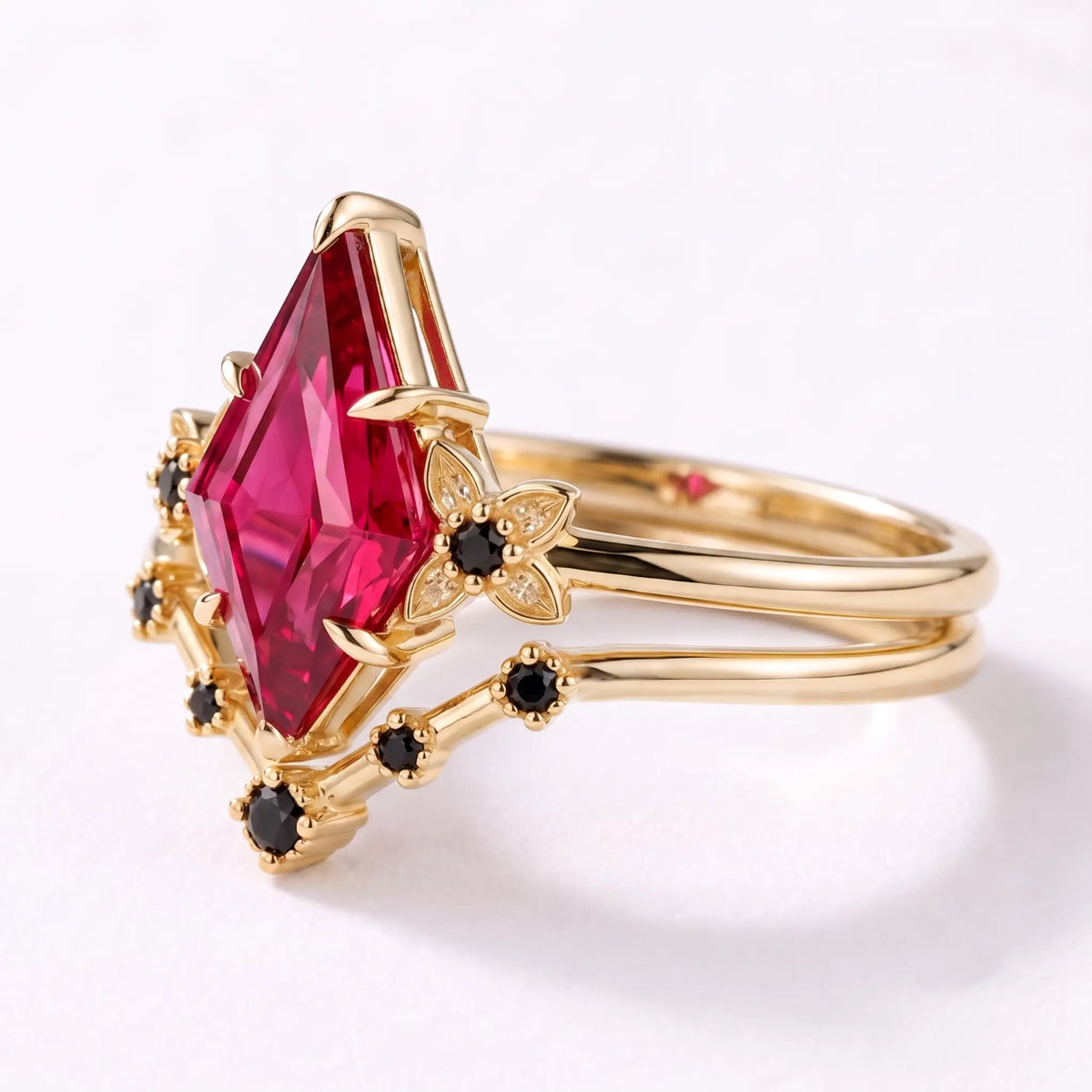 Left view of kite ruby bridal ring set with floral black onyx accents and matching band