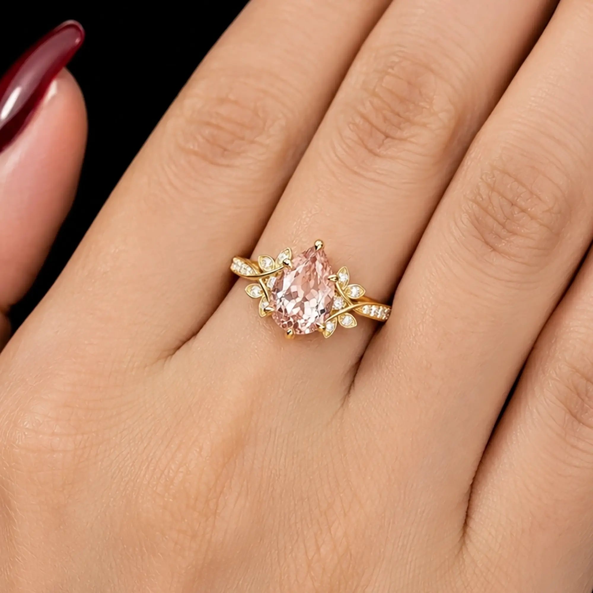 Pear cut morganite cluster engagement ring worn on hand