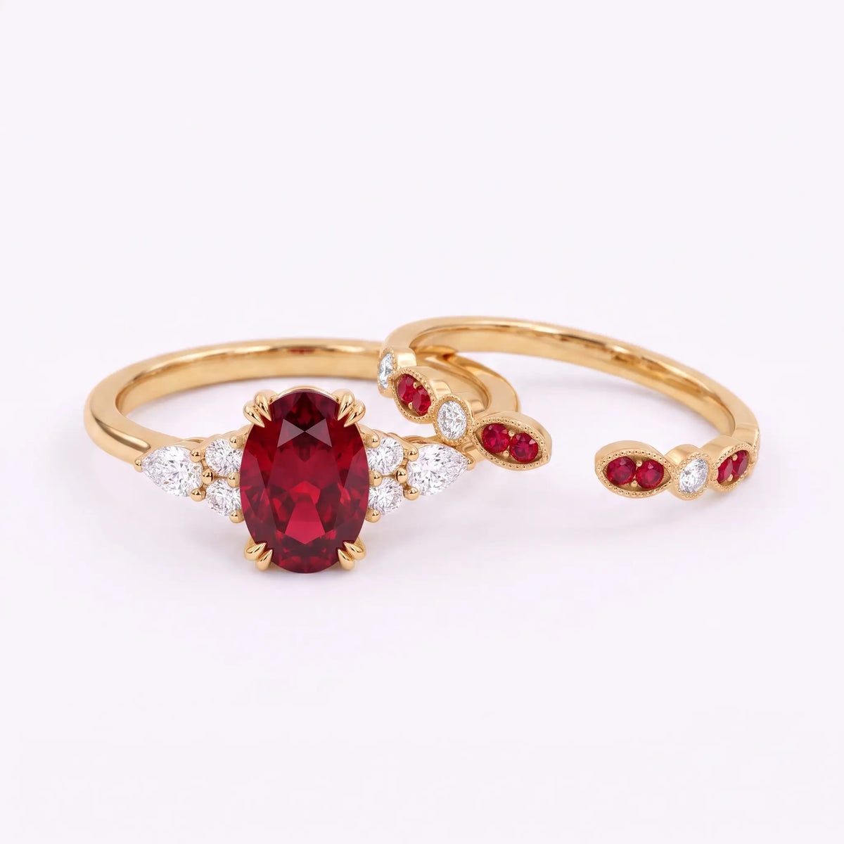 Oval ruby engagement ring and matching band displayed separately in one frame
