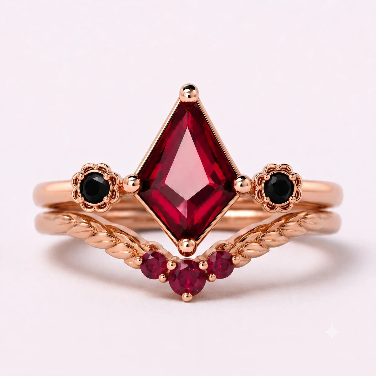 Kite cut ruby bridal ring set with black onyx accents and leaf-inspired curved band in rose gold