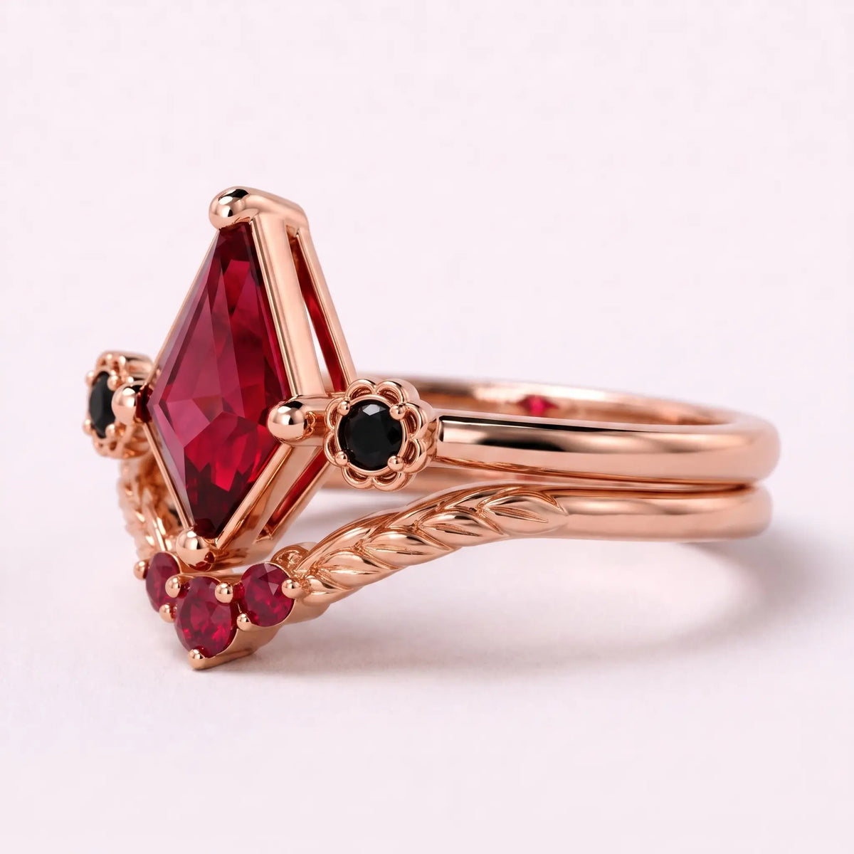 Left view of kite ruby bridal ring set with black onyx side stones and matching curved band