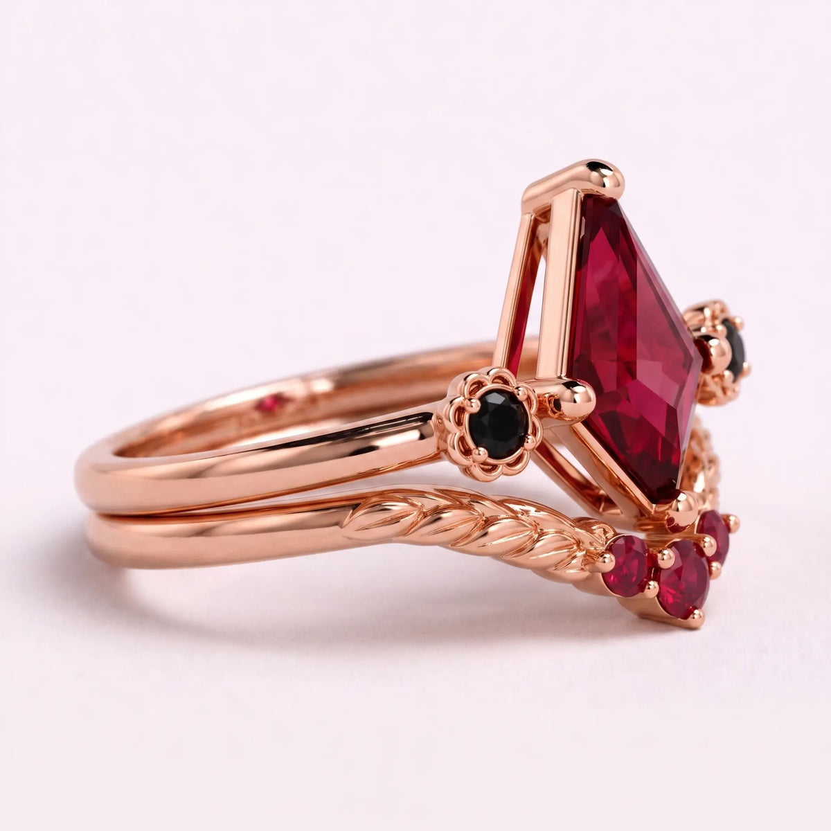 Close-up of kite cut lab ruby center stone with black onyx accents and ruby curved band