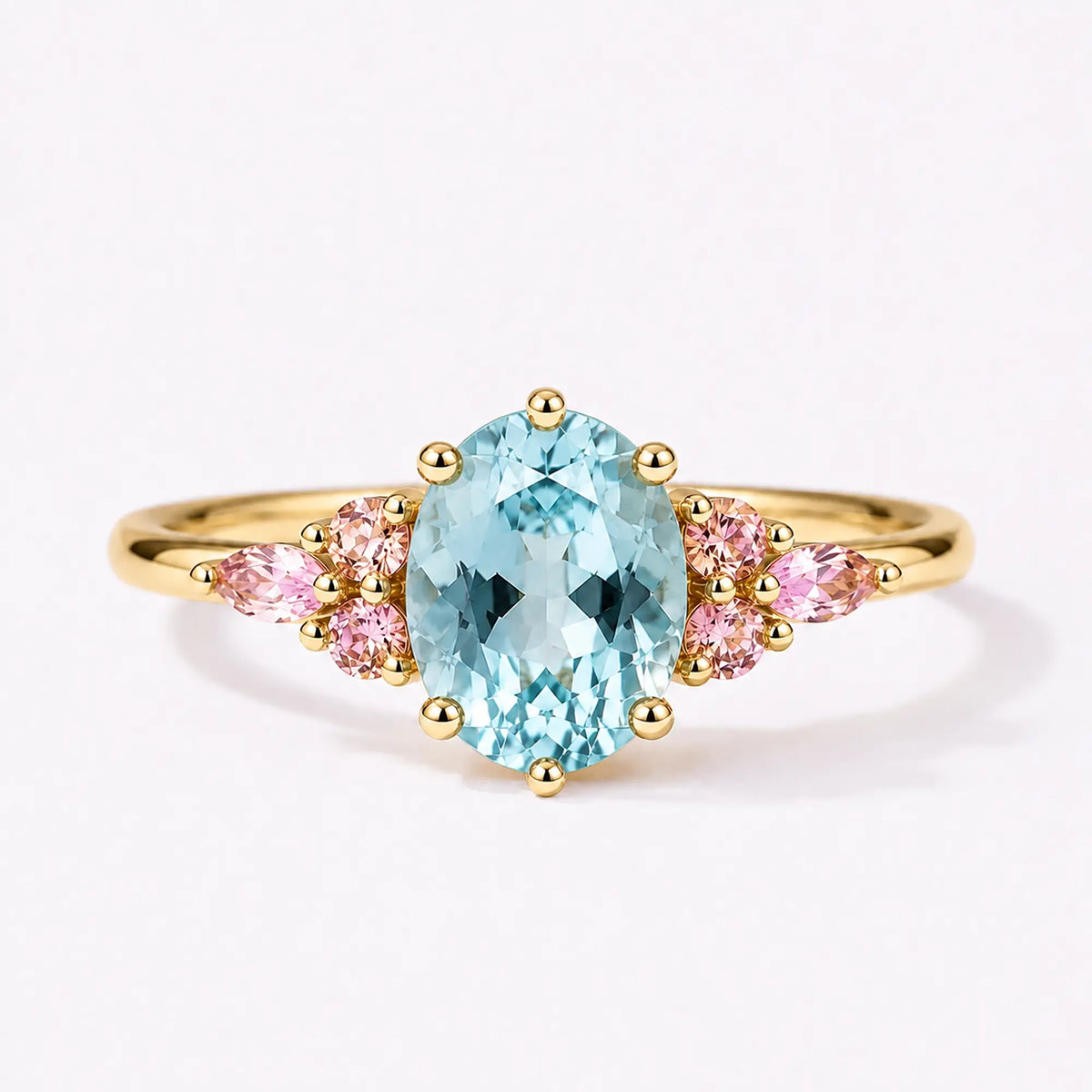 Classic oval aquamarine engagement ring with pink quartz cluster accents in yellow gold